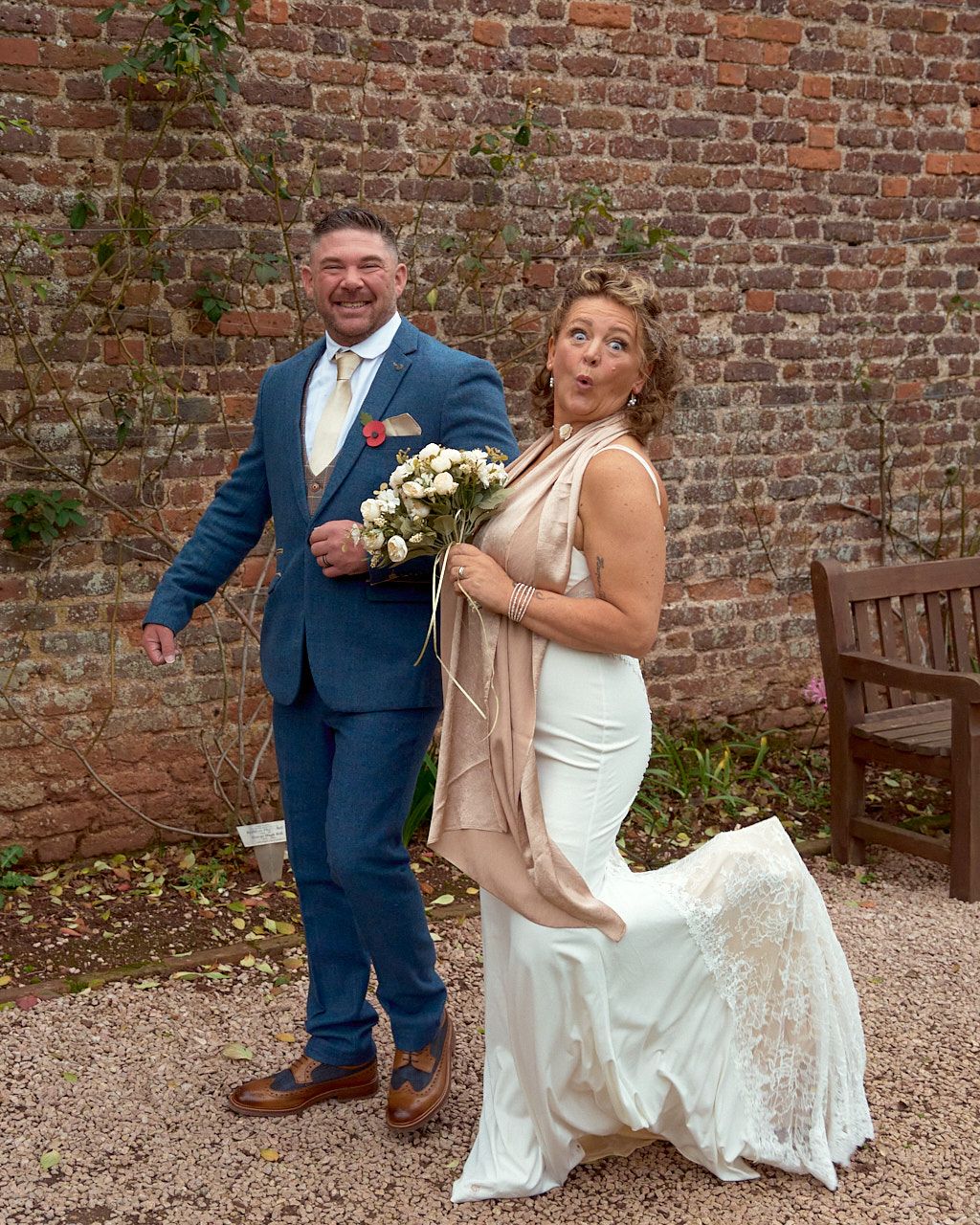 A couple poses for a series of romantic wedding photos against a rustic brick wall backdrop.