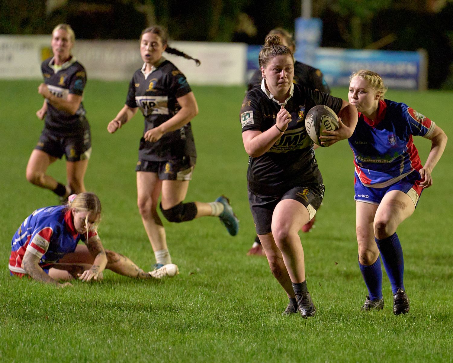 Brixham rugby player breaking through the line during an intense match on a grass field at Astley Park, Brixham RFC Sirens.