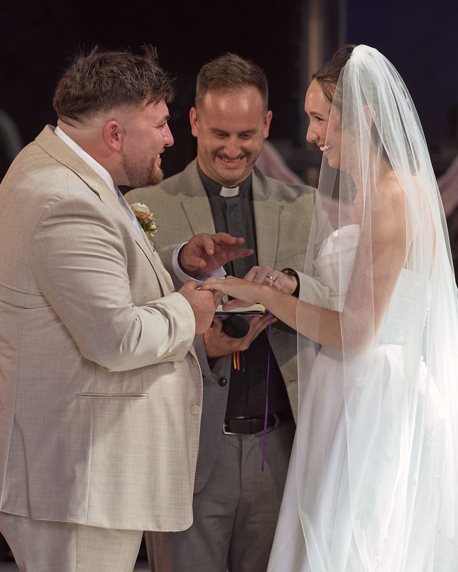 Bride and groom exchanging rings during their wedding ceremony.