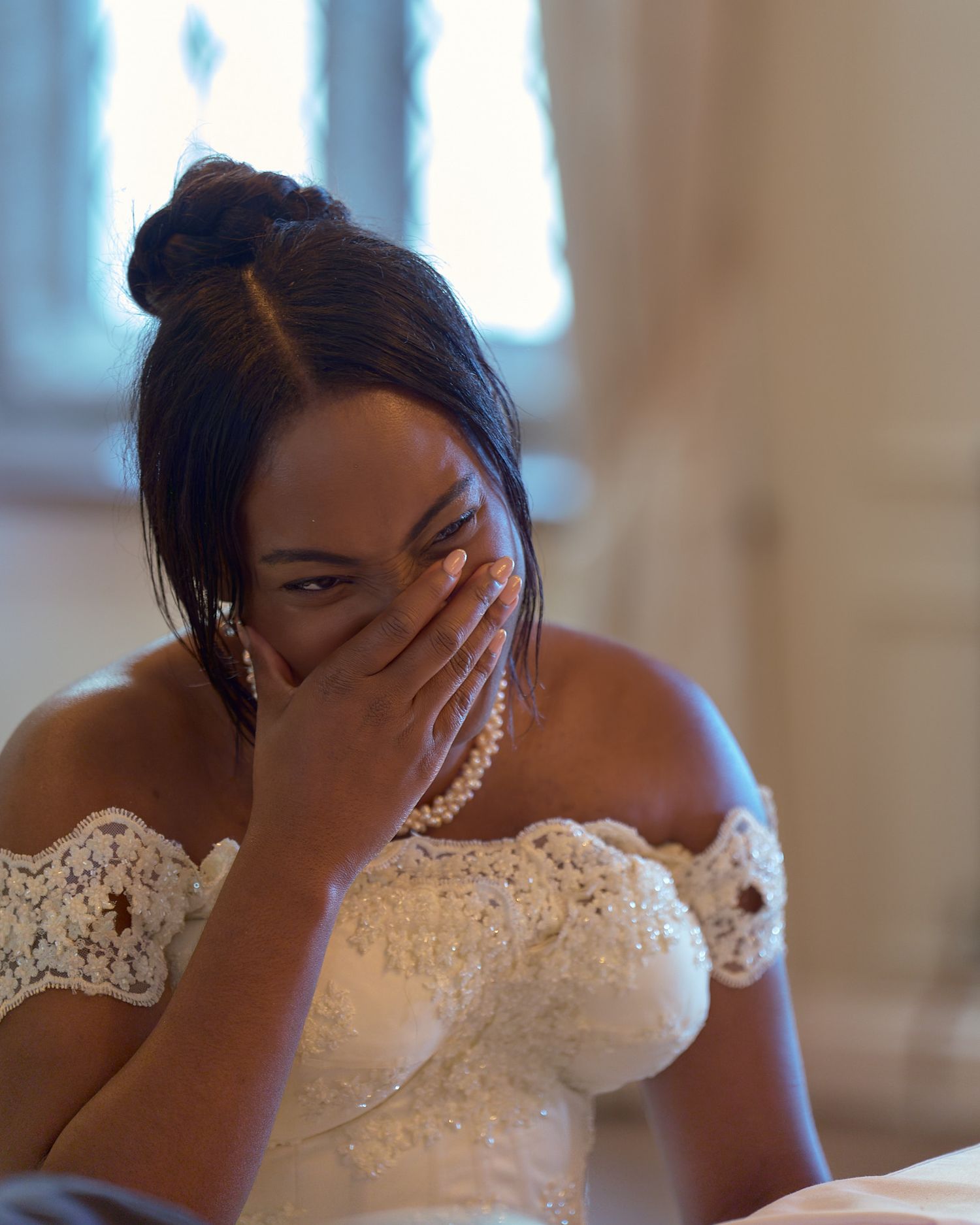 Bride covering her mouth during an emotional moment on her wedding day.