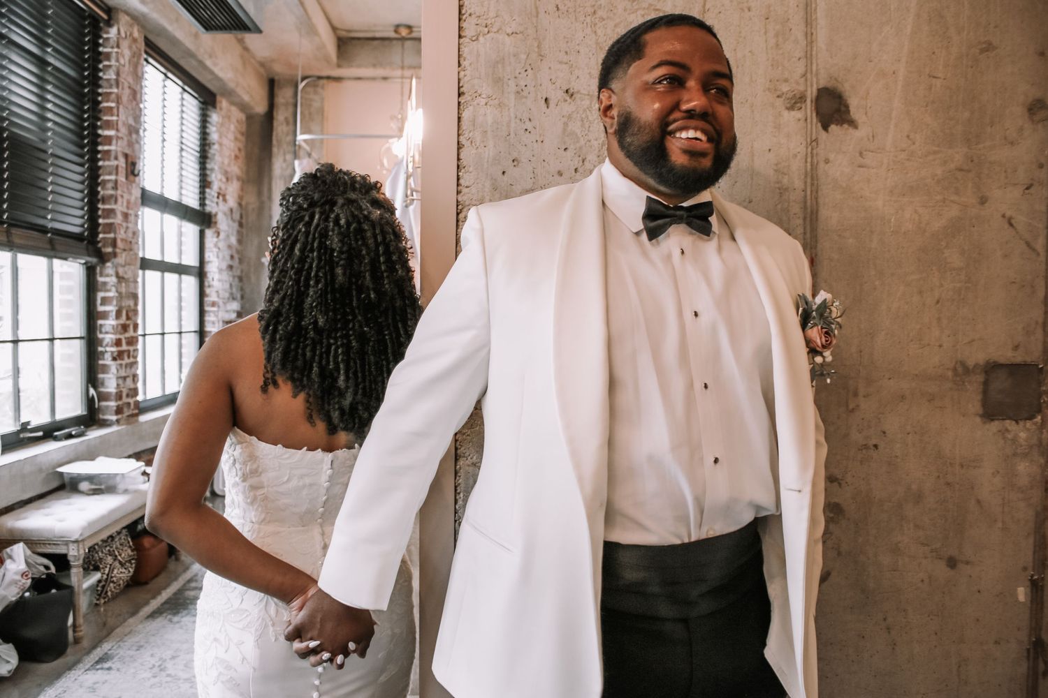 Wedding celebration candid moments captured in an industrial brick venue setting.
