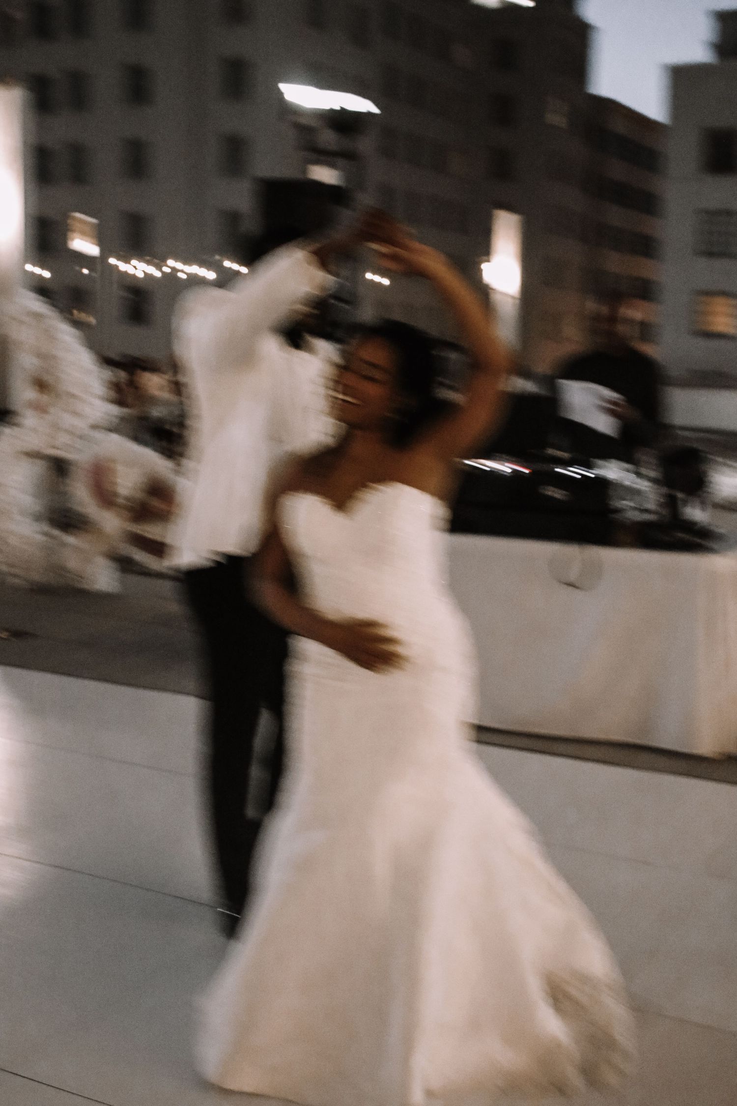 Blurred motion shots of wedding couple dancing on rooftop.