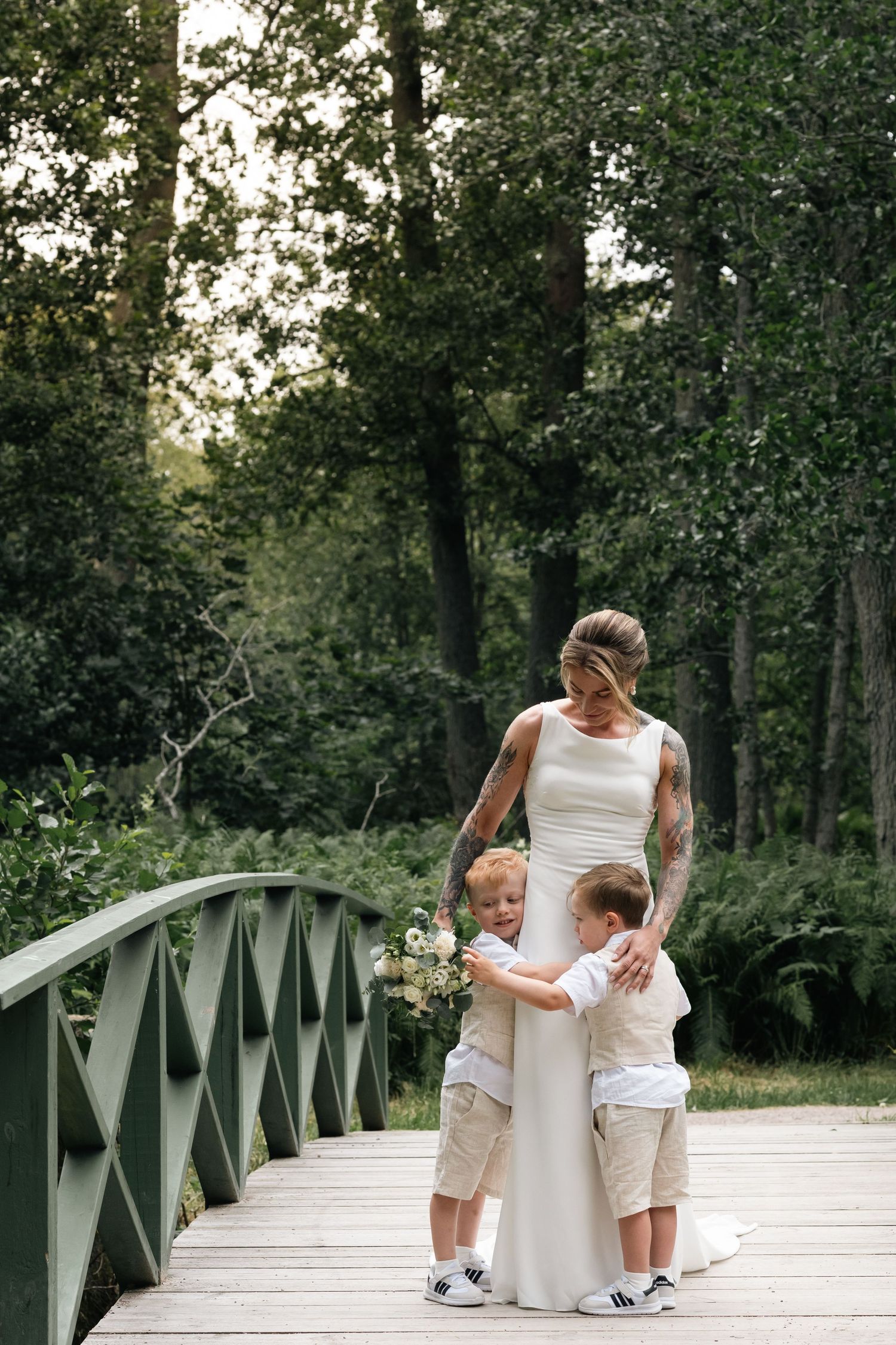 Sweet moment captured on wooden bridge with flowing white dress.
