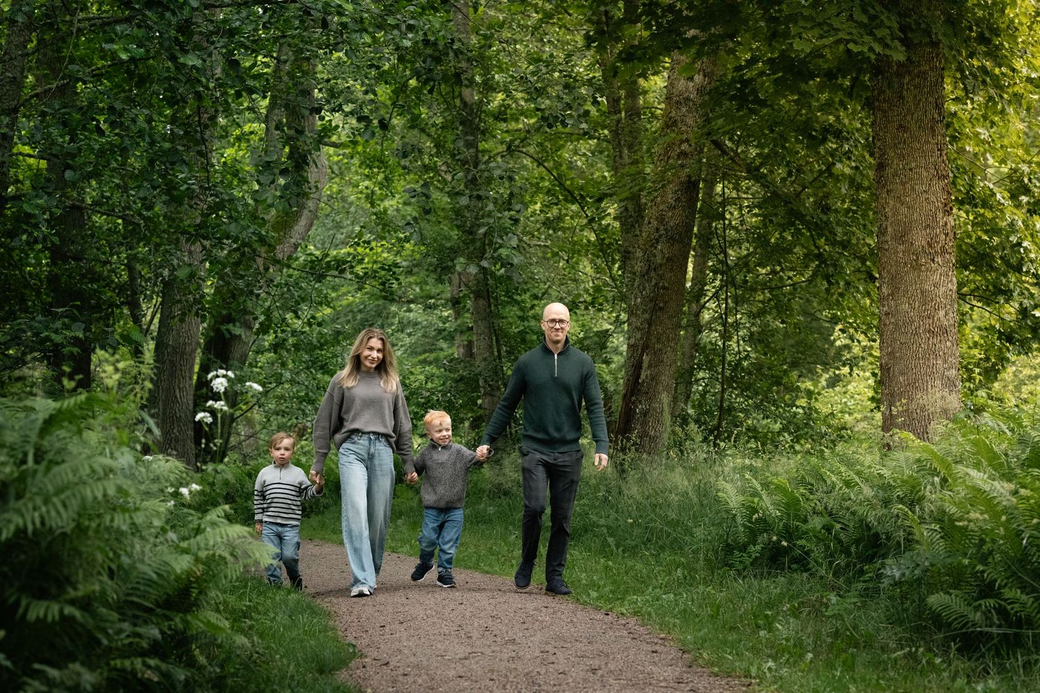 Group walking together on tree-lined nature path in afternoon sunlight.