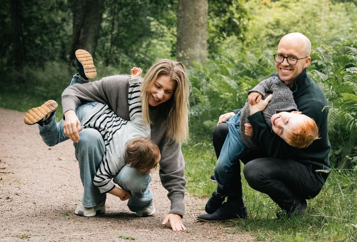 Playful group having fun outdoors in casual clothing on forest path.