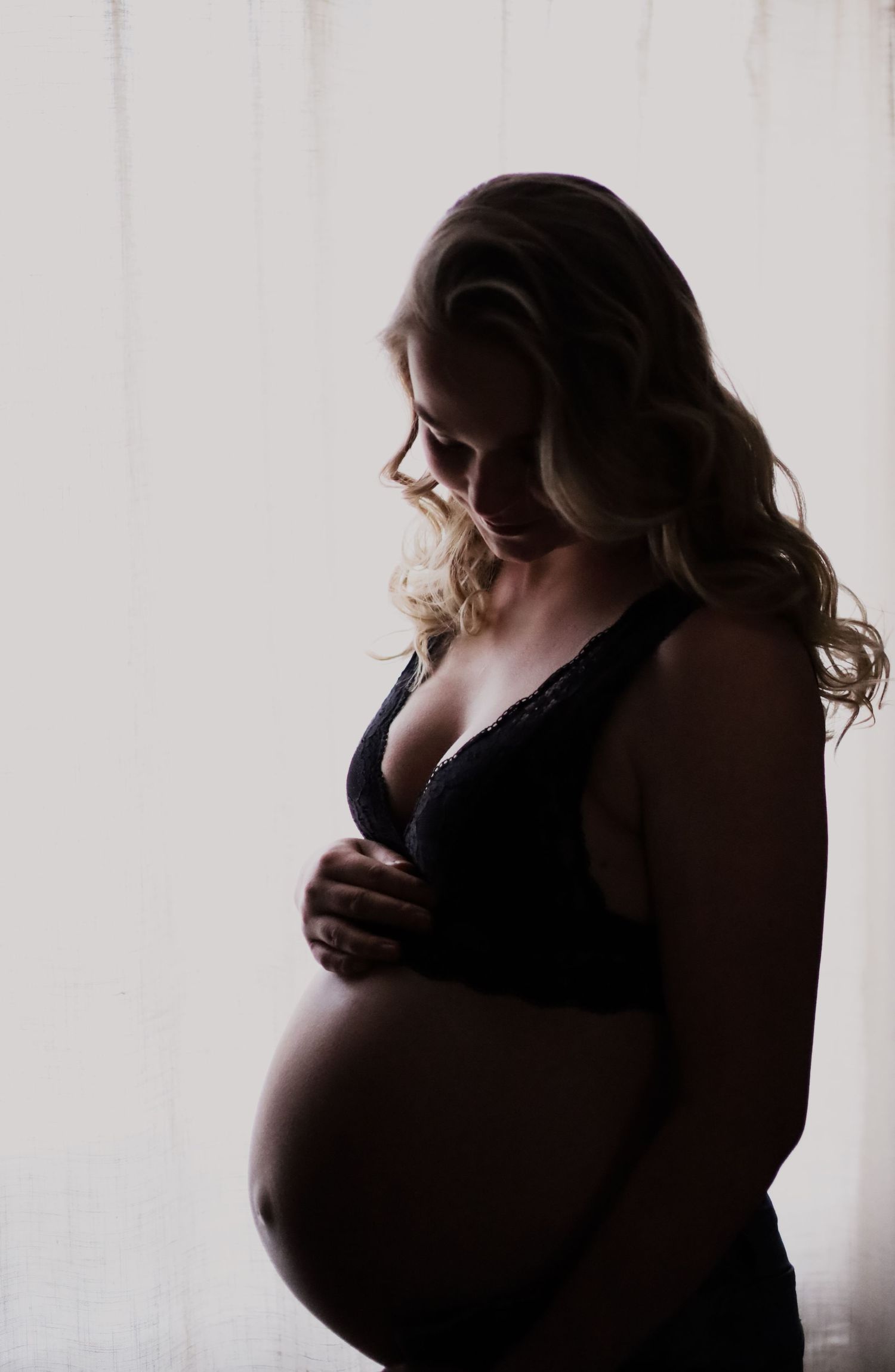 Artistic silhouette maternity photos in soft window light.