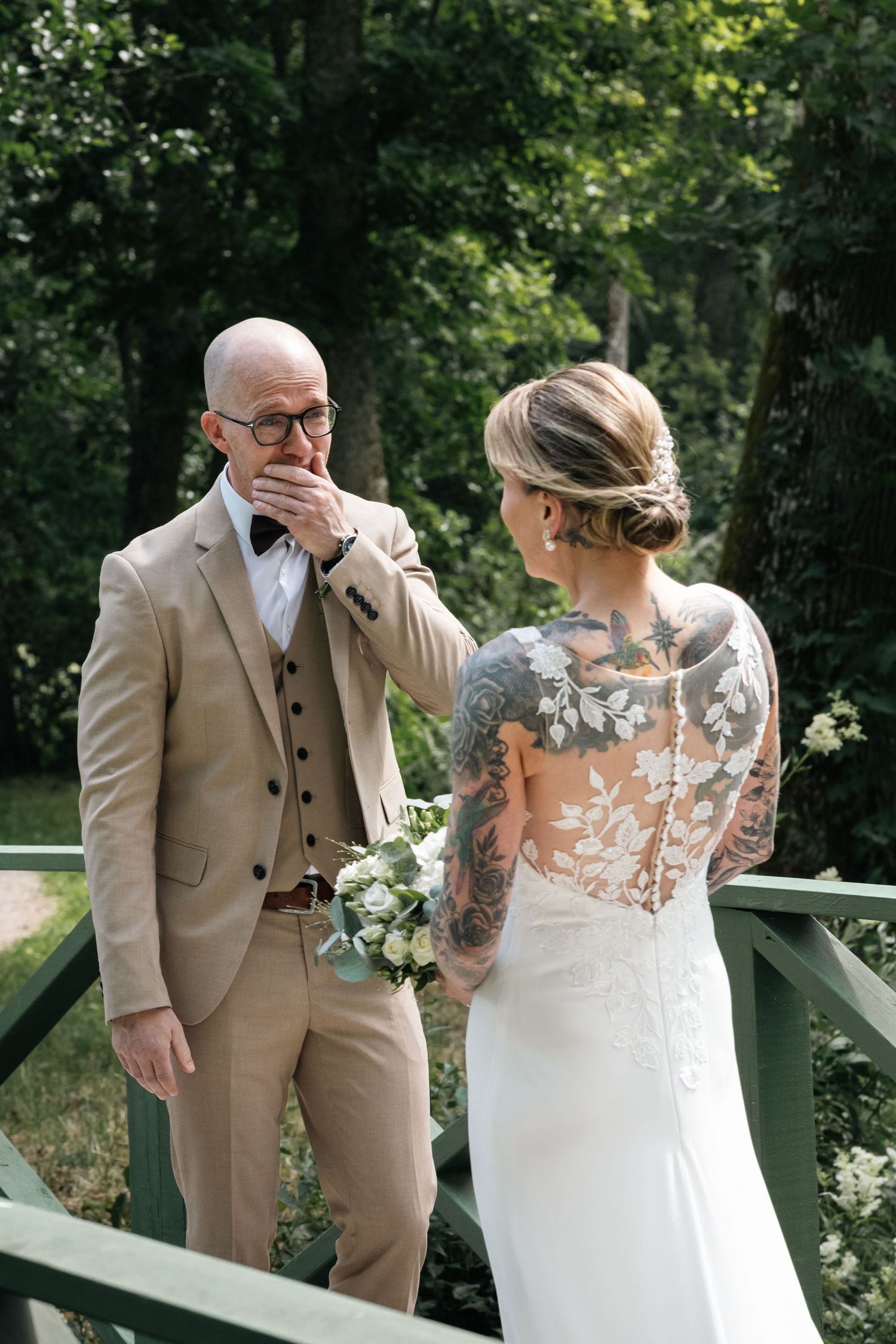 A first look wedding moment captured in a garden setting with emotional reactions.