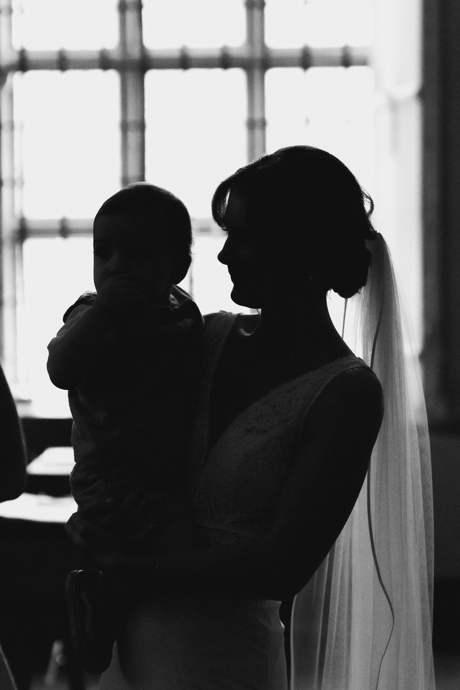 Black and white silhouettes of people drinking from cups against a bright window background.