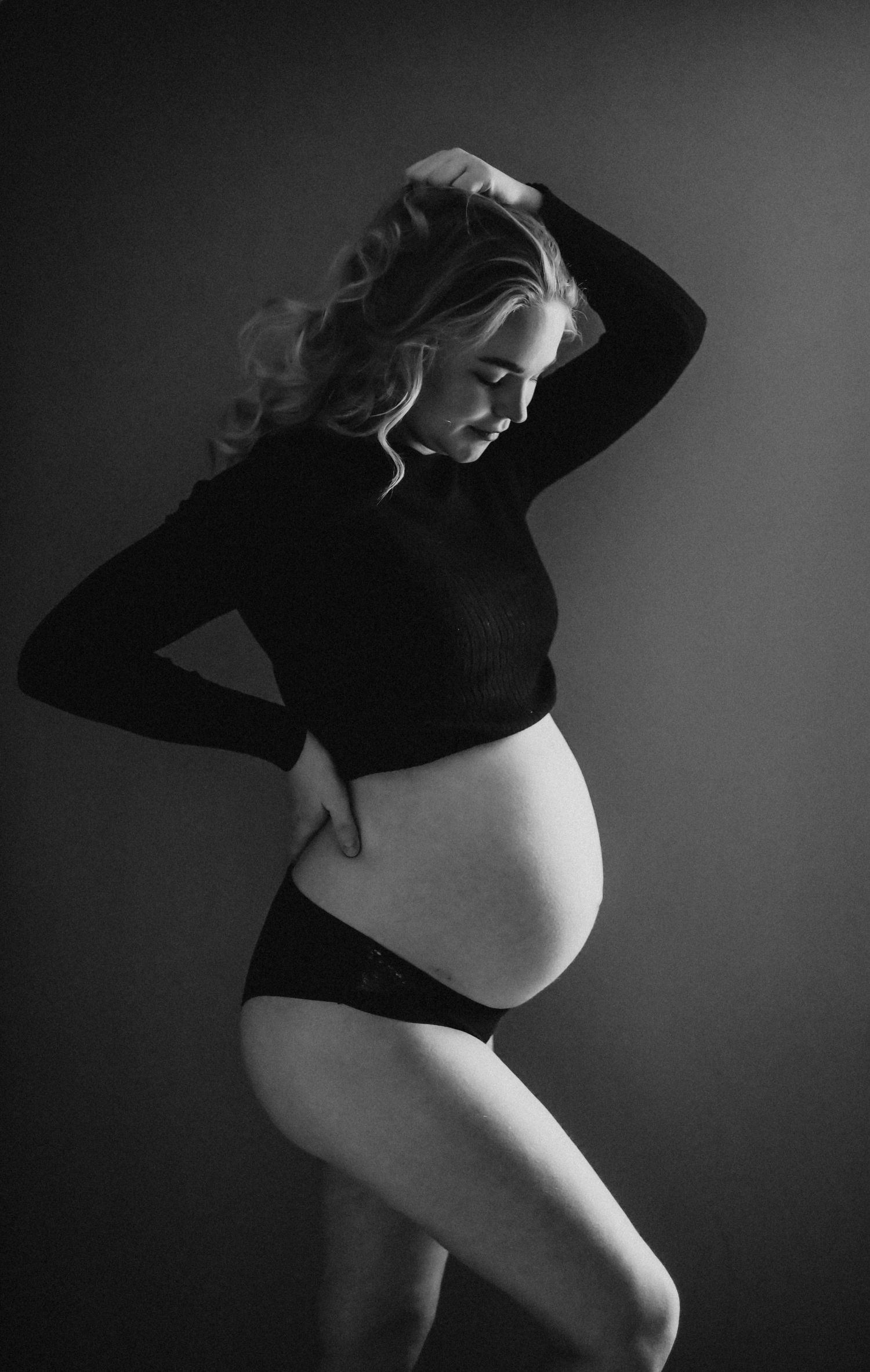 Dramatic black and white maternity portraits with artistic lighting.