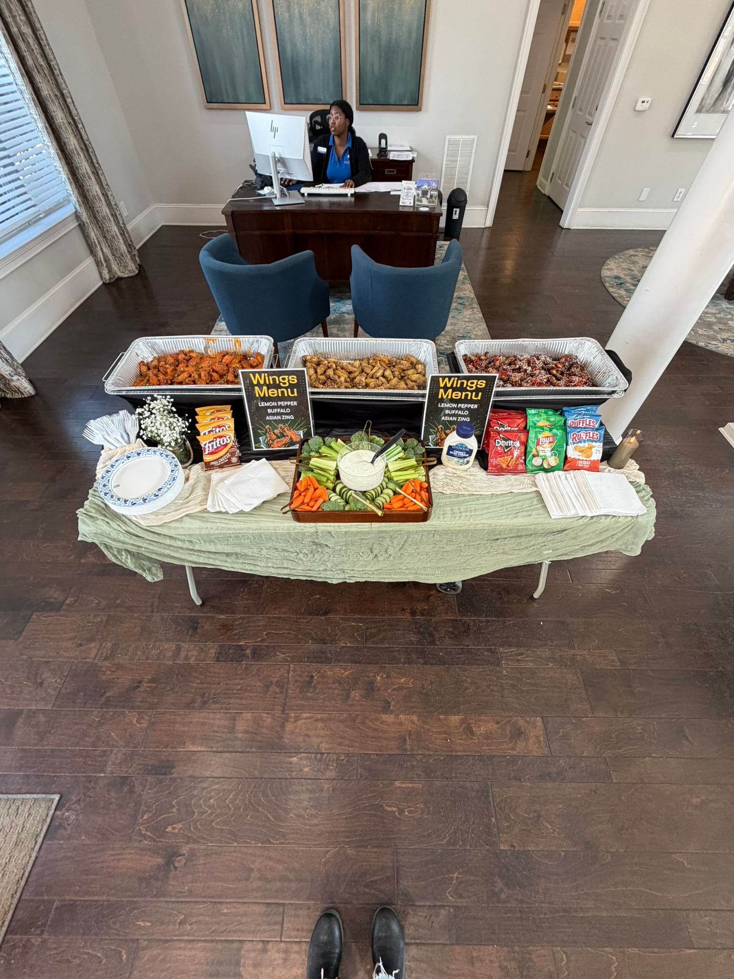 Overhead view of a buffet table with wings, veggie tray, and snacks set up in an elegant room.