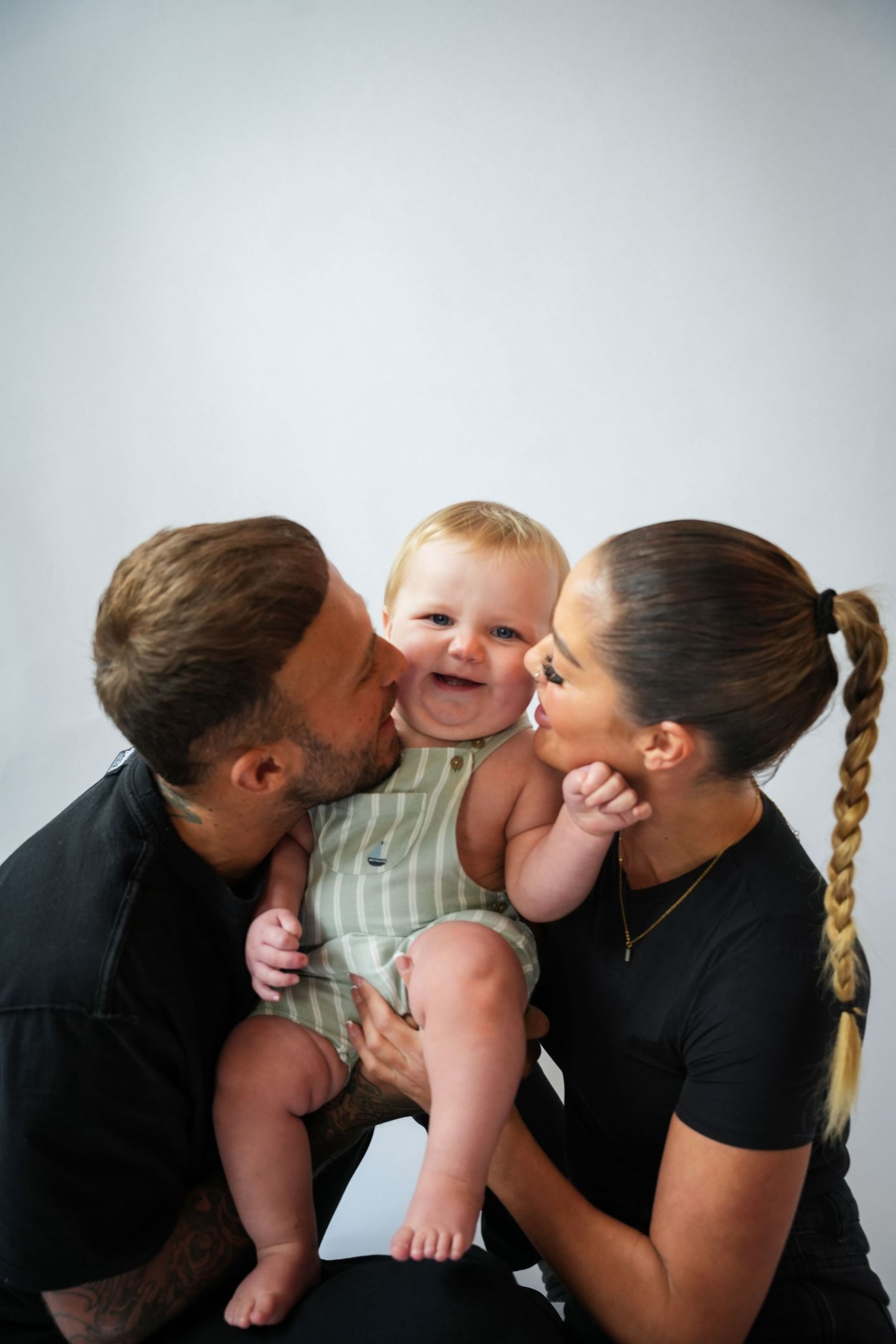 Photo of mum, dad and baby, light, airy background with natural lighting
