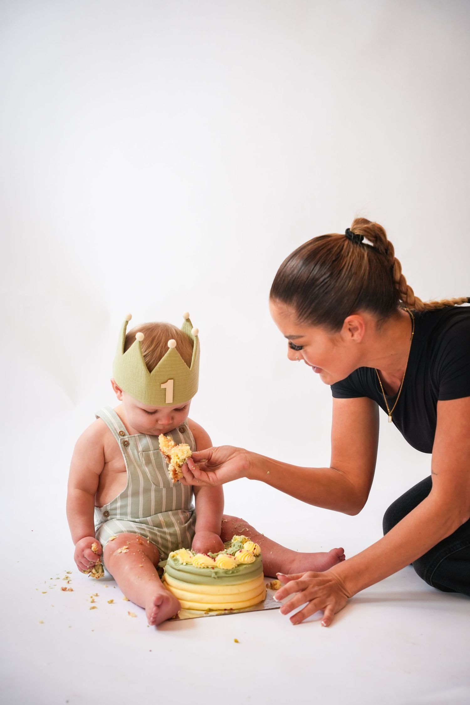 Photo of mum and baby with a birthday cake light, airy background with natural lighting