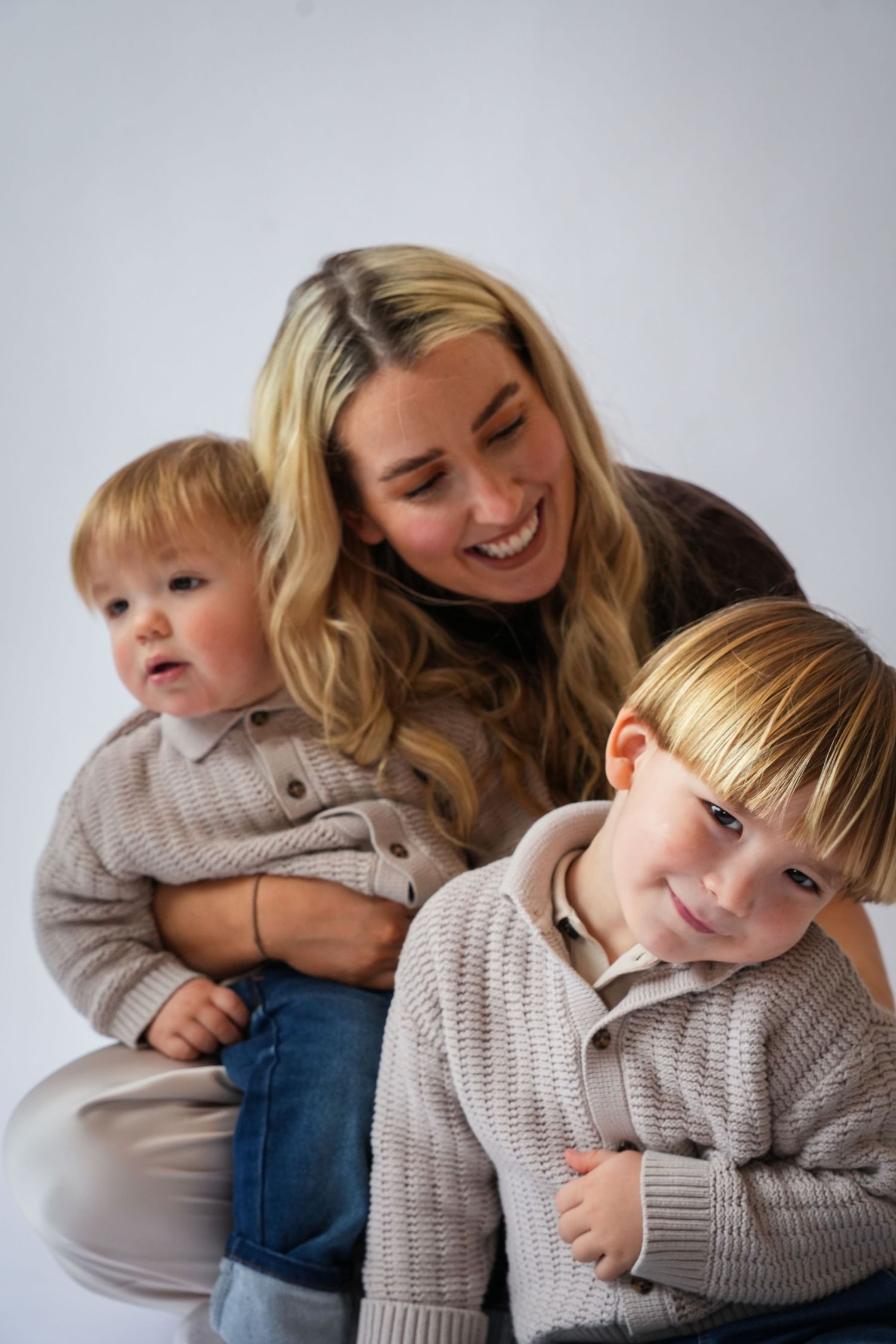 Photo of mum and baby and toddler laughing, light, airy background with natural lighting