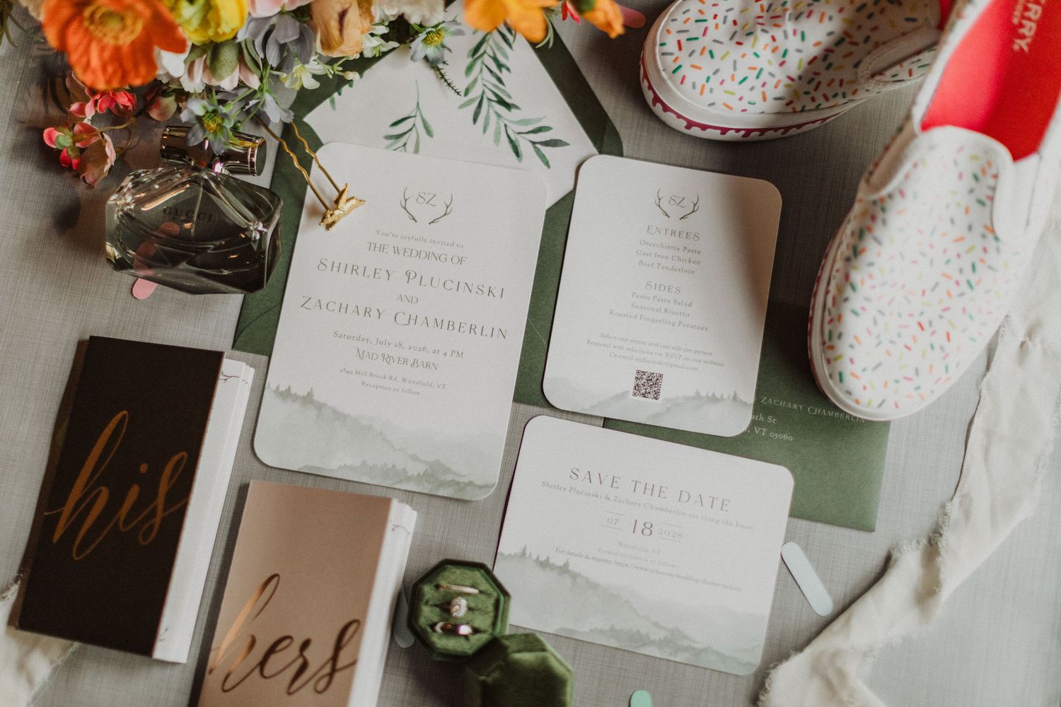 Elegant wedding invitation suite with greenery accents, save the date cards, and floral arrangements on a white background.
