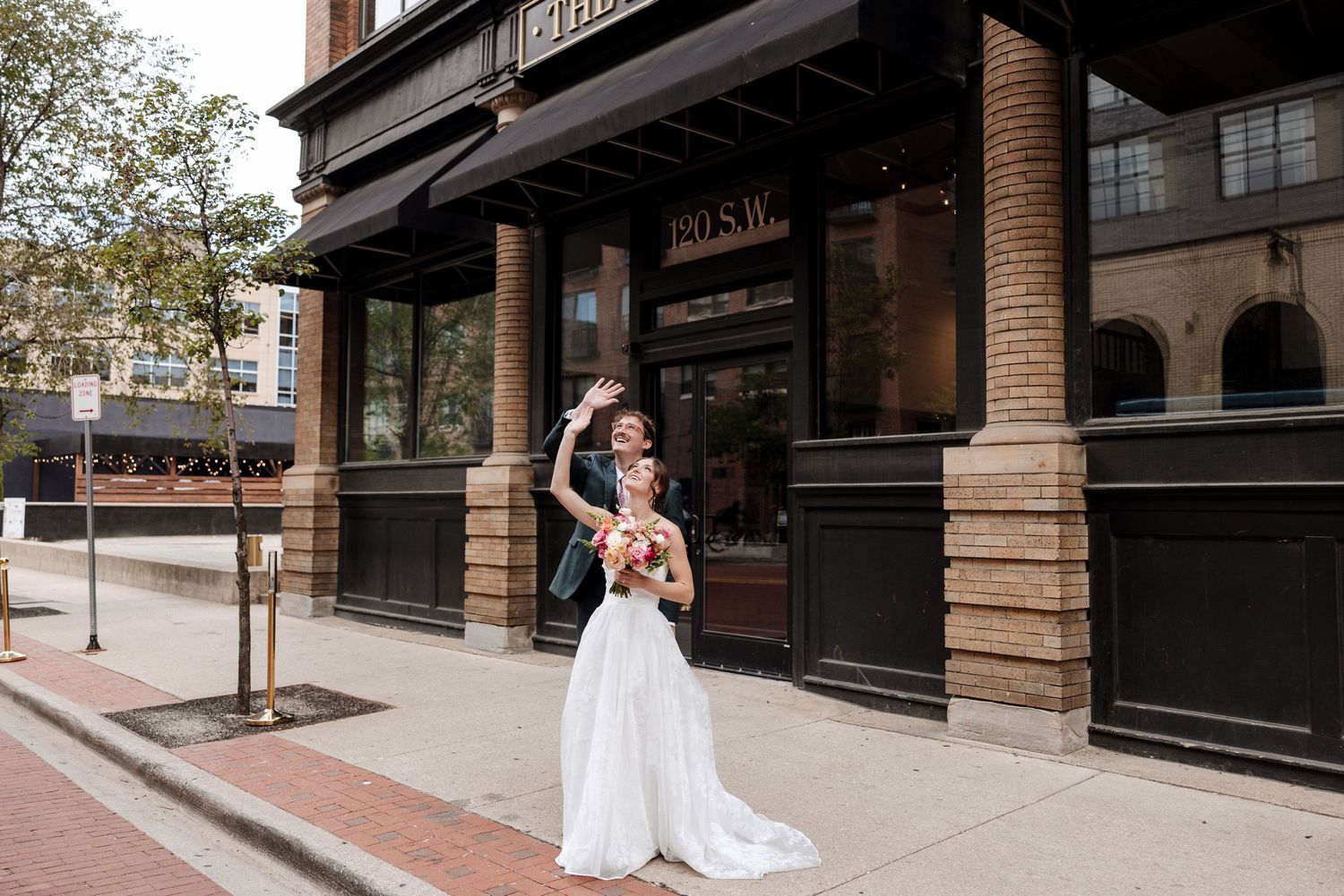 Bride and groom celebrate outside The Rutledge venue with colorful bridal bouquet.