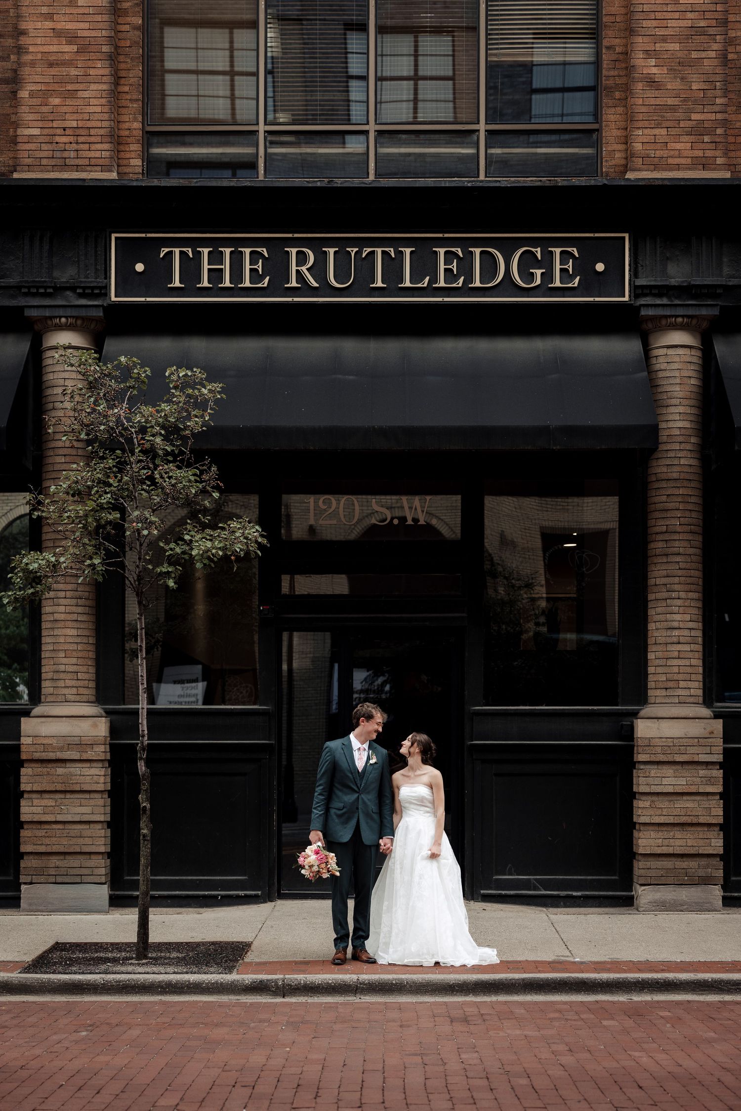 Wedding couple shares a romantic moment outside The Rutledge building on their special day.