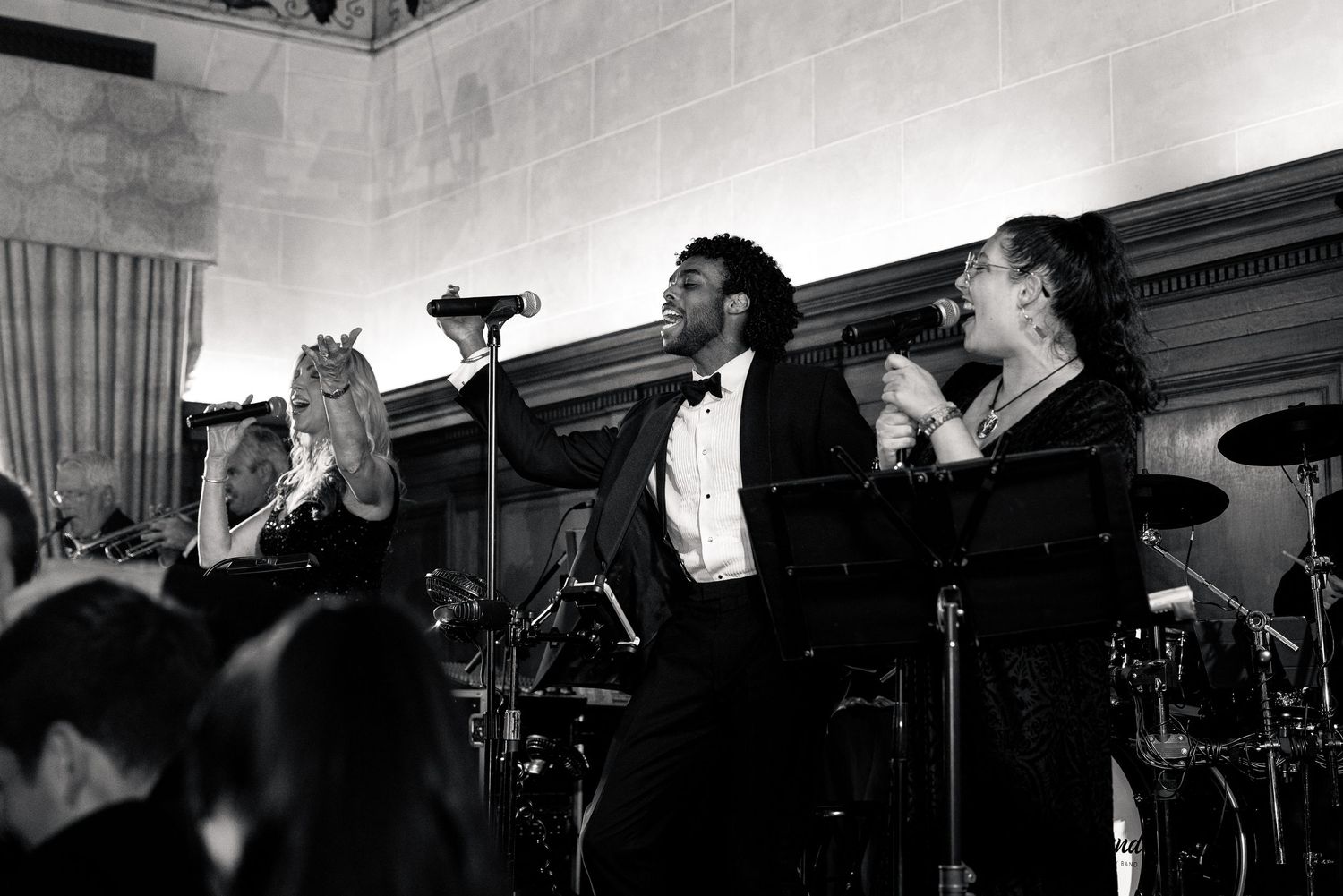 Black and white photo of a live band performing at a formal wedding reception.