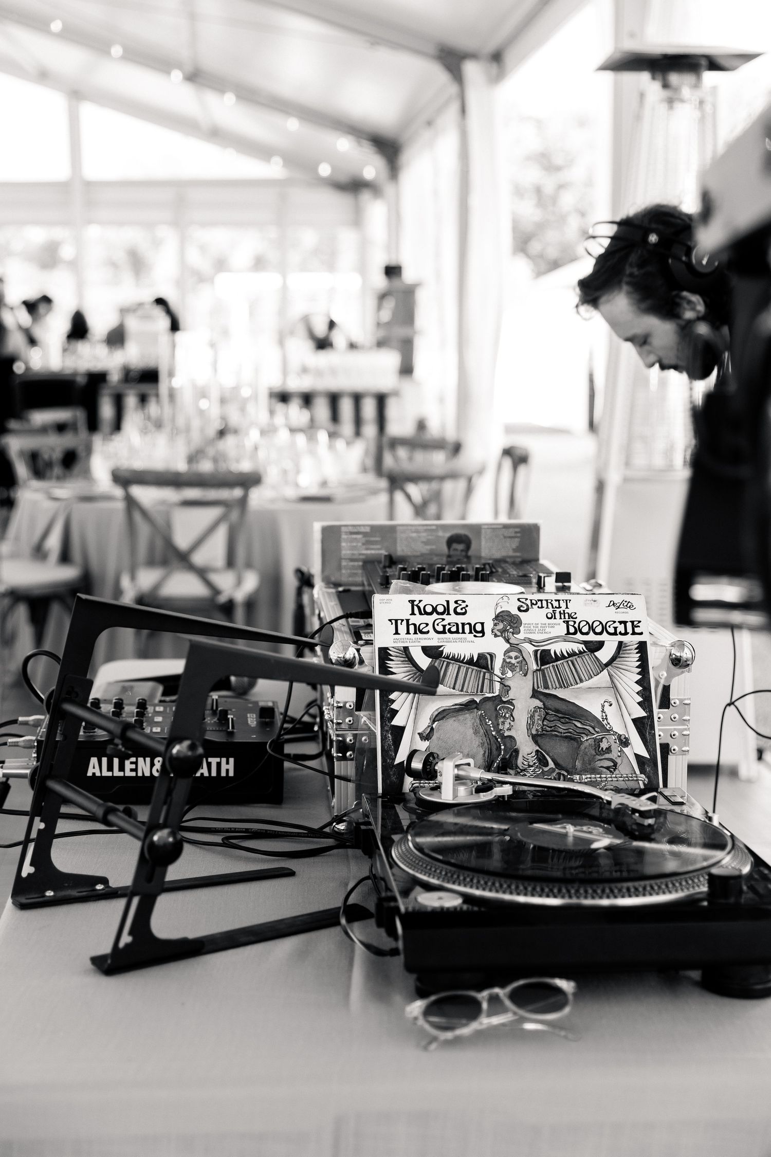 Black and white photo of DJ setup with vinyl turntable and Kool and the Gang record at wedding reception.