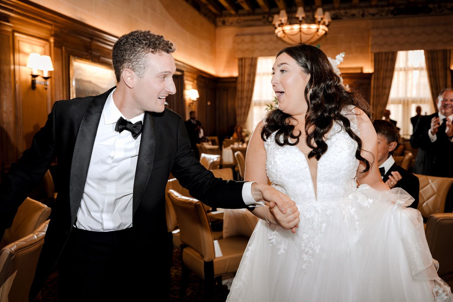 Joyful bride and groom dancing together at elegant wedding reception venue.