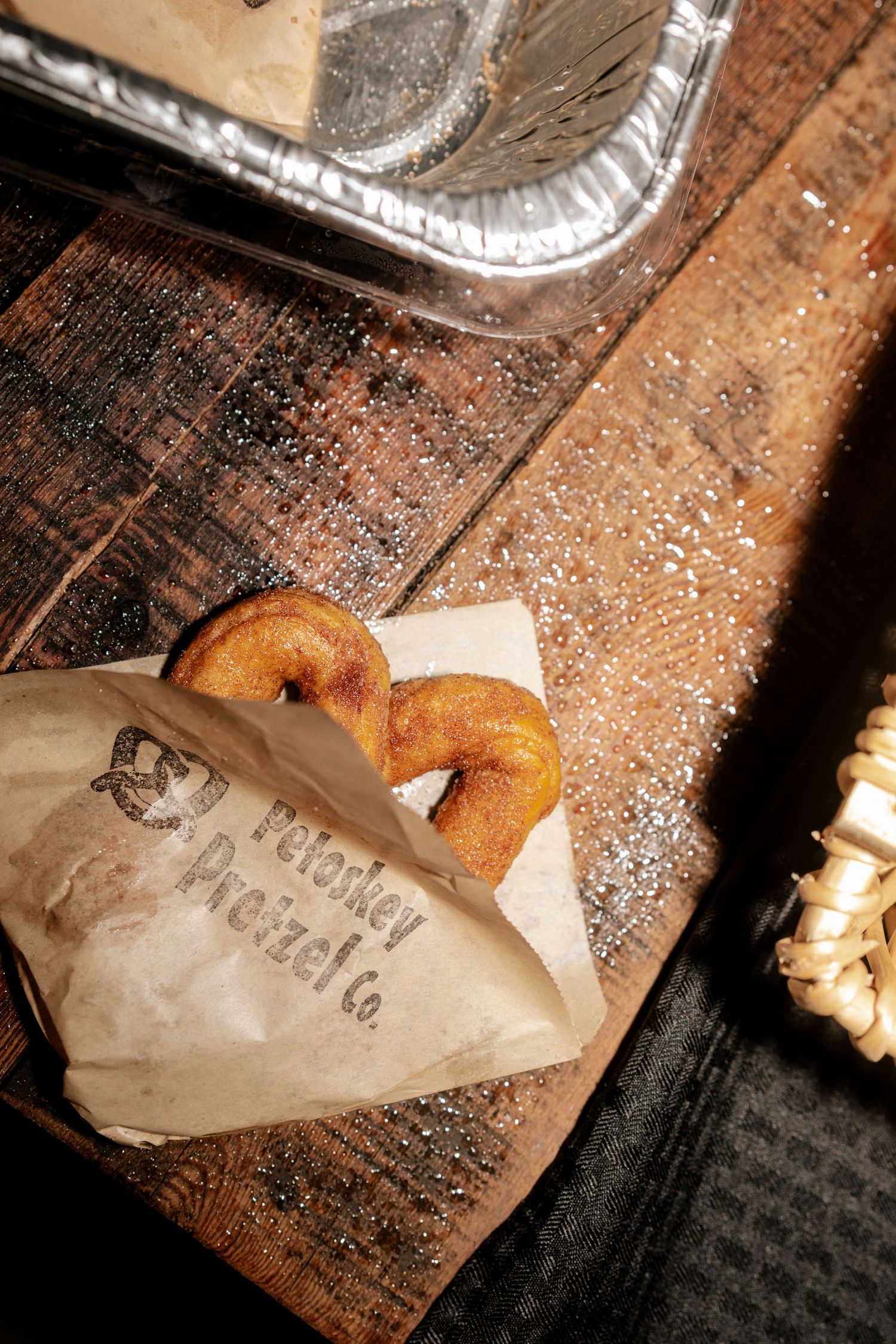 Petoskey Pretzel Co. pretzels in a paper bag displayed on a rustic wooden board at a wedding reception.