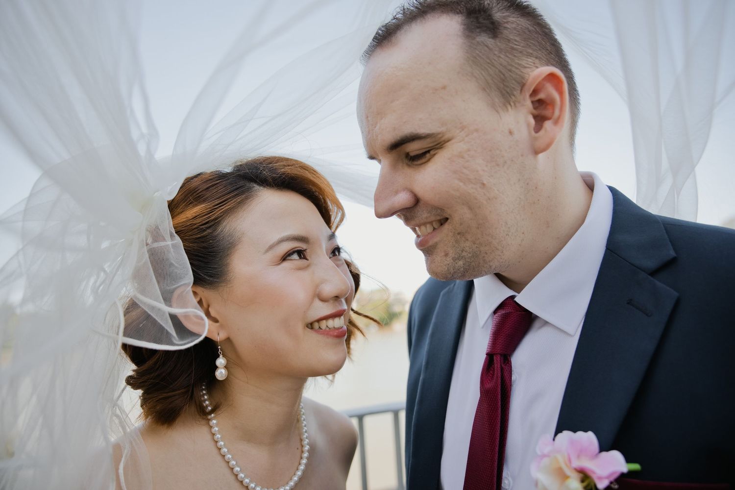 close up portrait of couple, veil flowing in wind