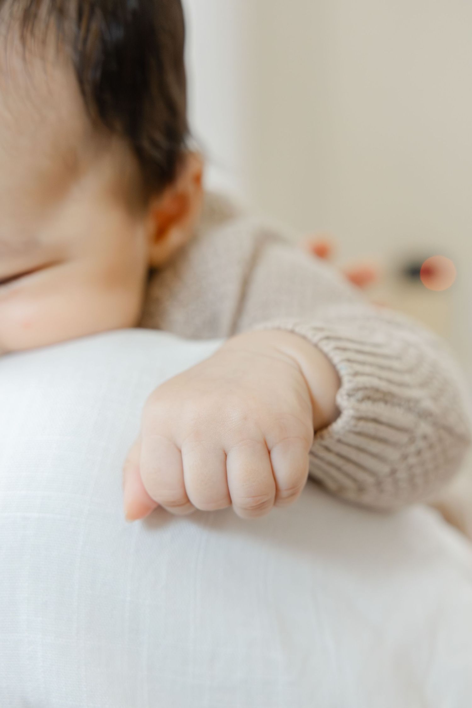 baby hand in focus, face blurred