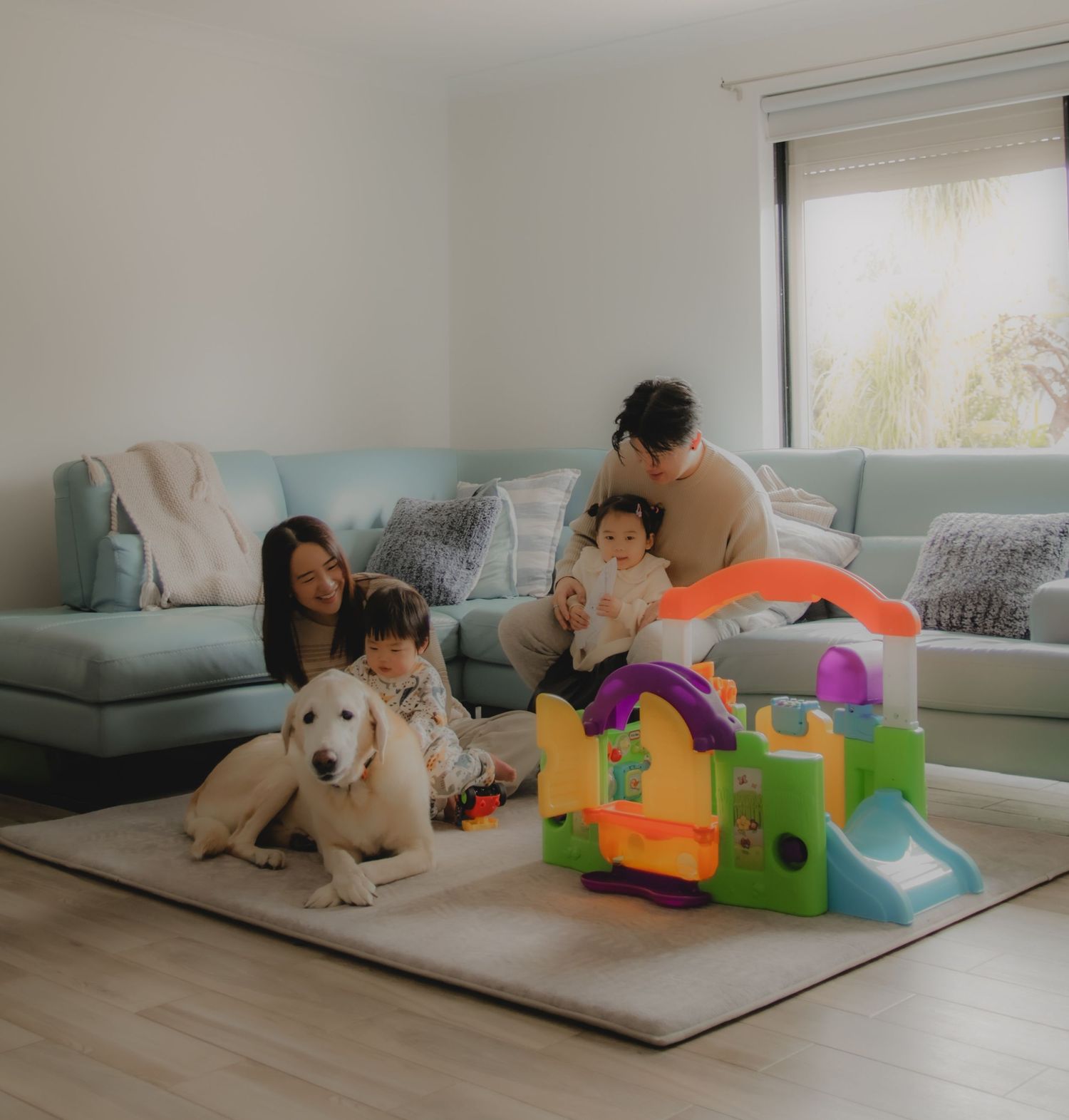 In-home family photoshoot in Singapore capturing candid moments between parents and children at home, with pet dog