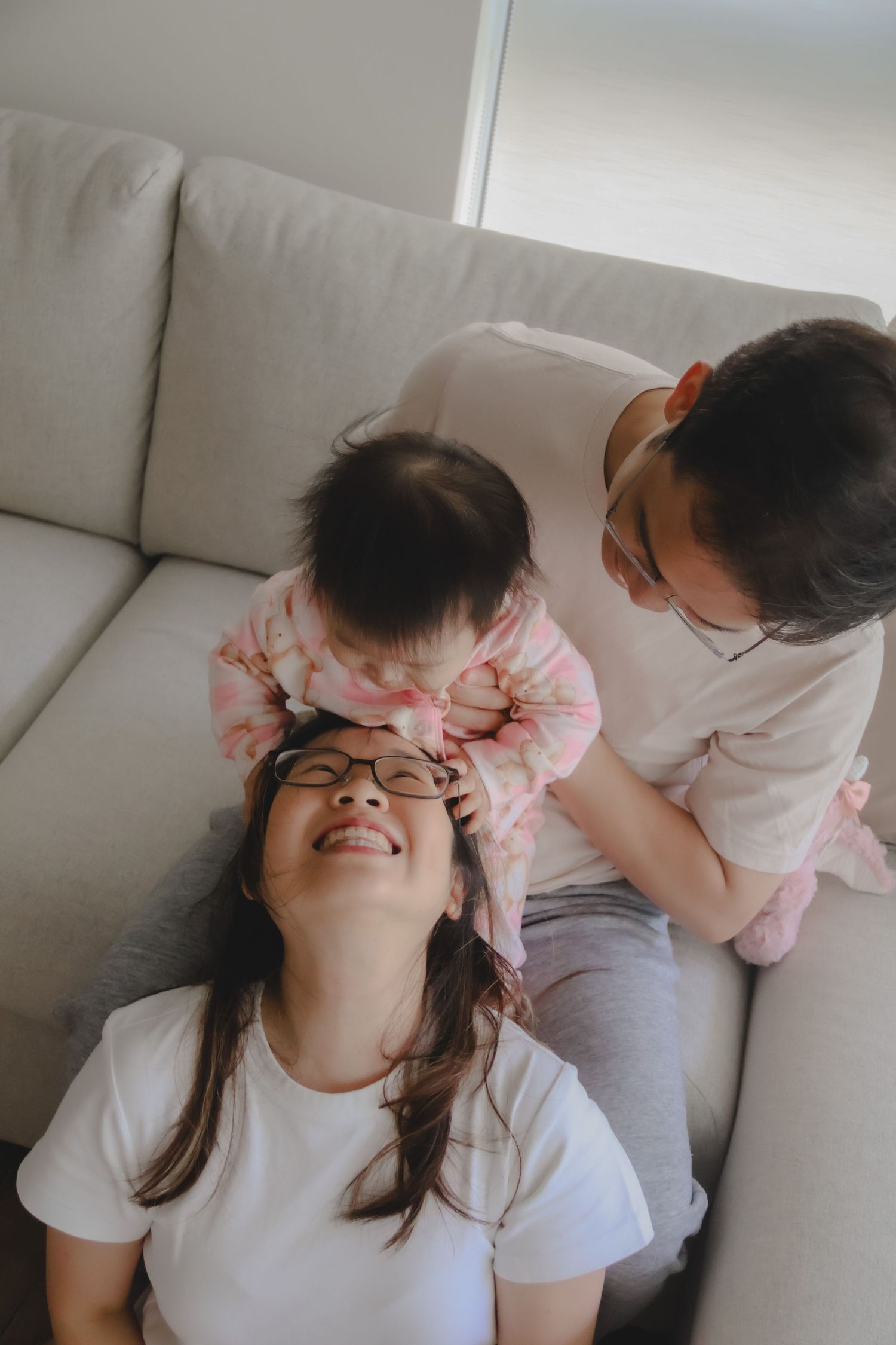 In-home family of 3 photoshoot in Singapore capturing candid moments between parents and children at home with natural lighting