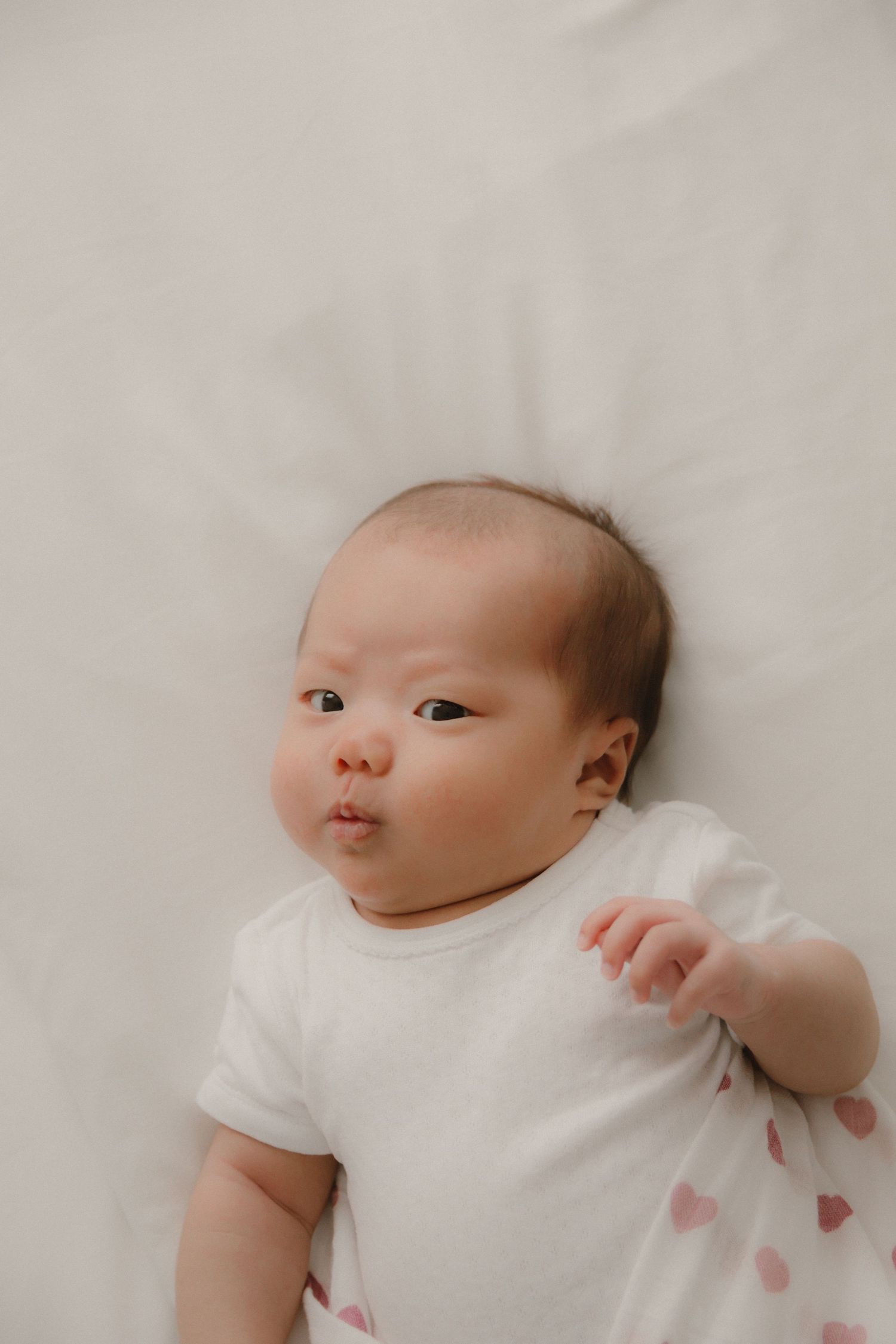 In-home newborn photography in Singapore documenting early days with soft natural light at home