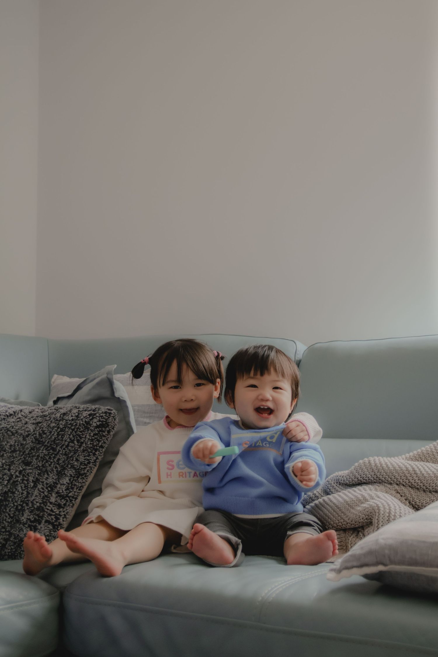 In-home family photoshoot in Singapore capturing candid moments between siblings at home