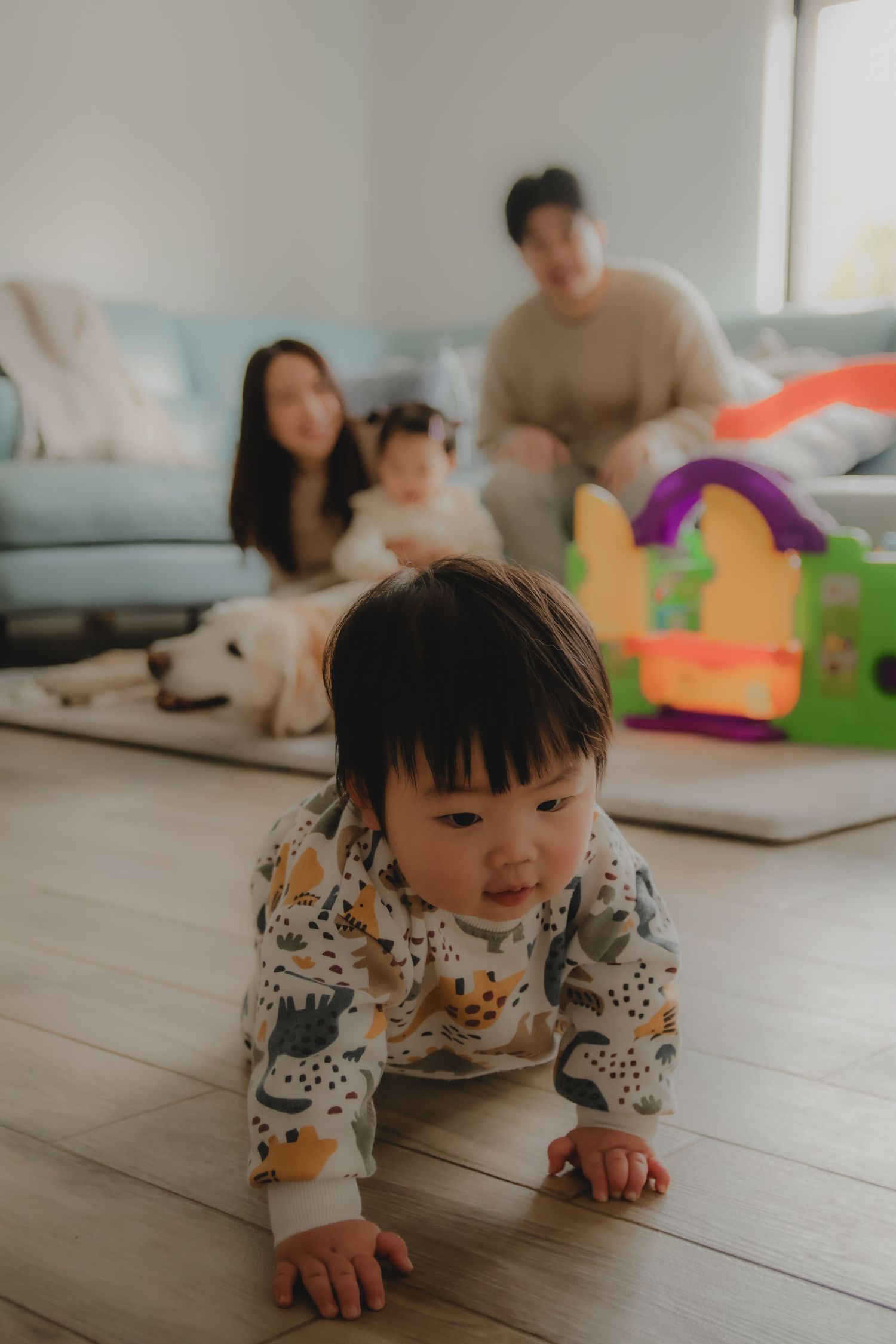 In-home family photoshoot in Singapore capturing candid moments between parents and children at home, with pet dog