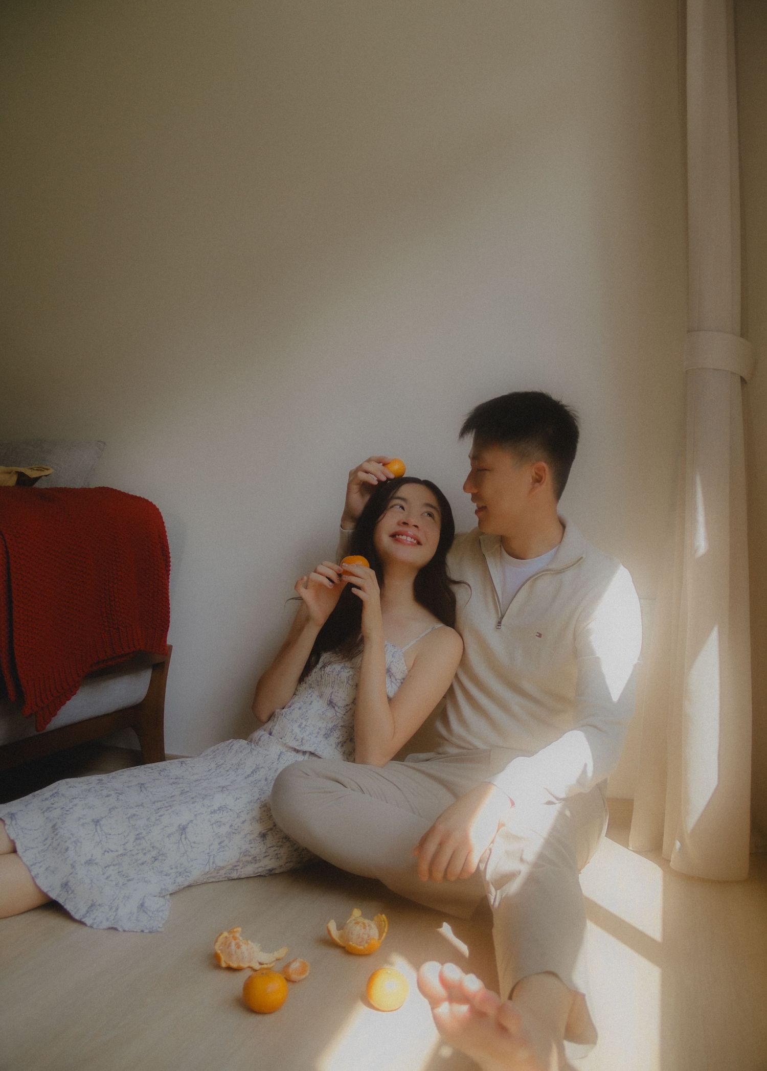 In-home couple photoshoot in Singapore with tangerines, warm, natural light and storytelling focus