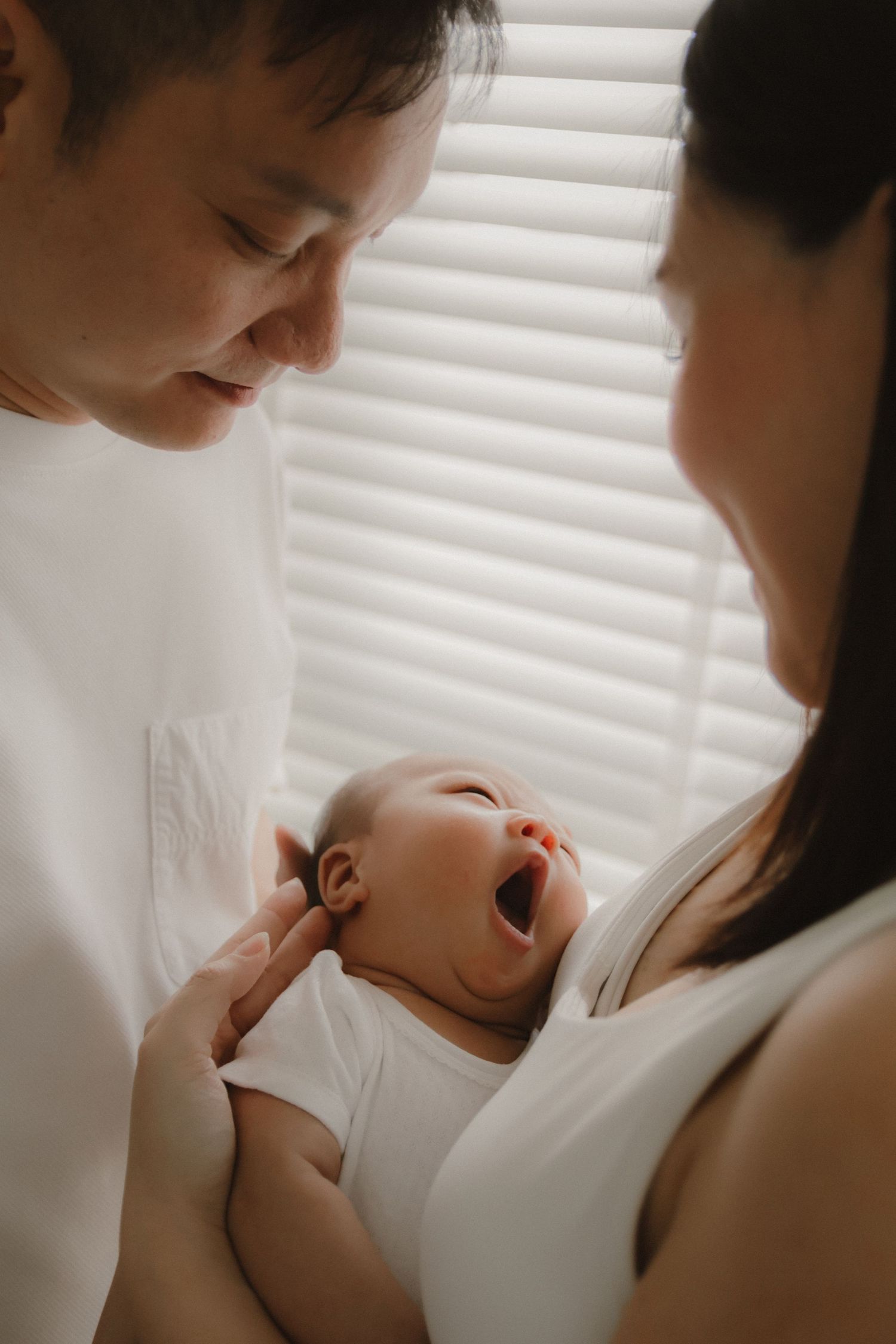 In-home newborn photography in Singapore documenting early days with soft natural light at home