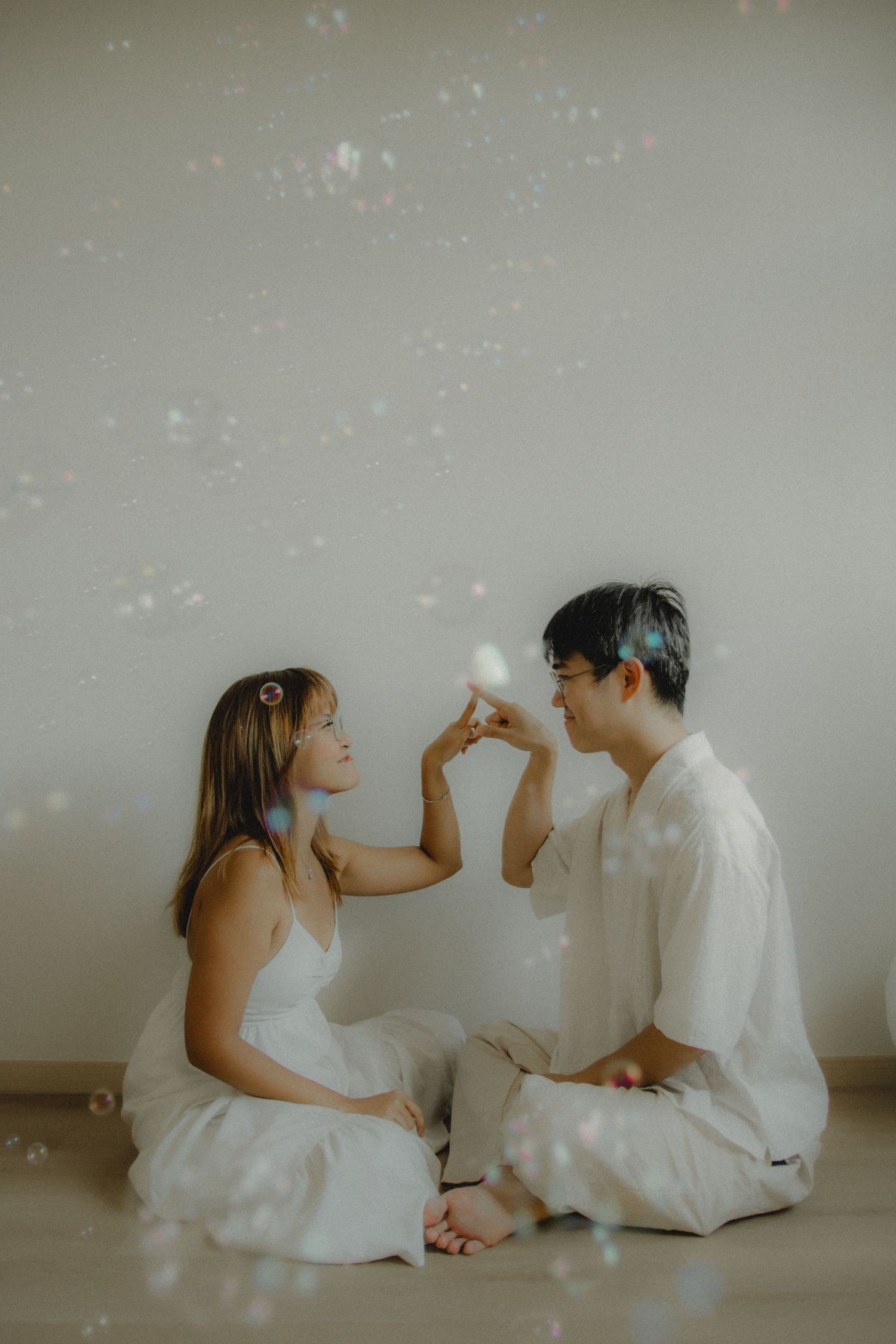 In-home couple photoshoot in Singapore with bubbles, warm, natural light and storytelling focus