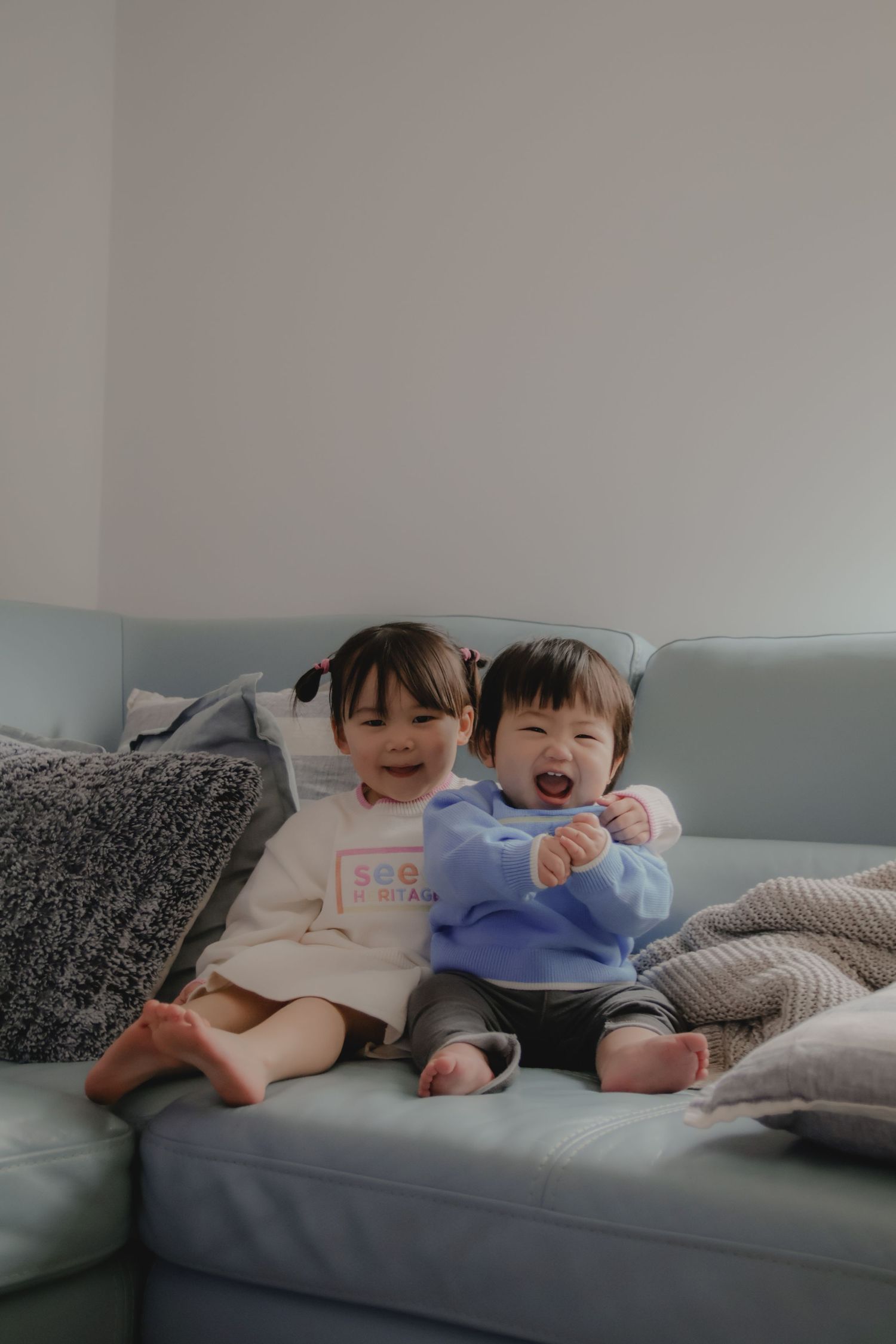 In-home family photoshoot in Singapore capturing candid moments between siblings at home