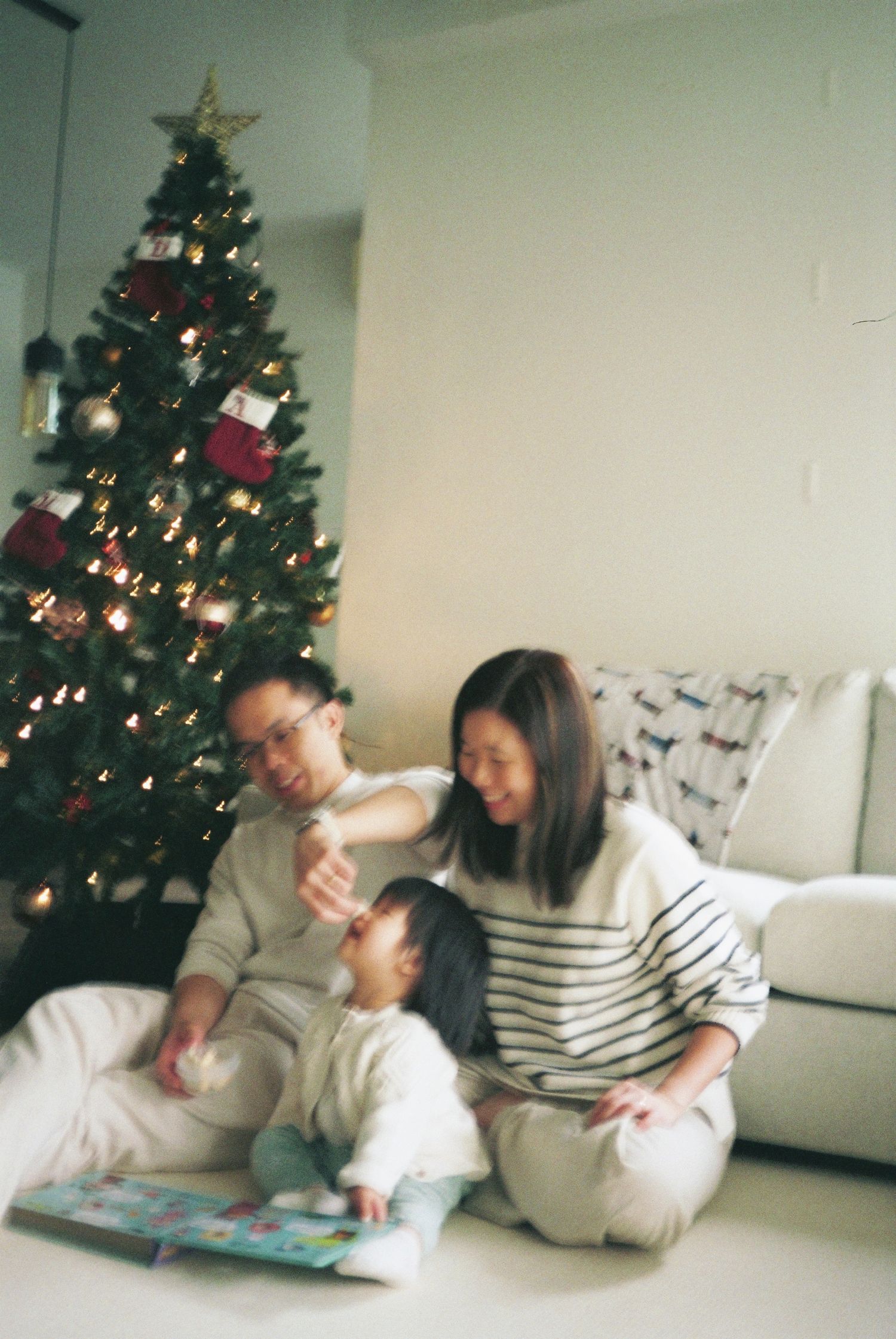 In-home family photoshoot in Singapore capturing candid moments between parents and children at home during Christmas, film photography