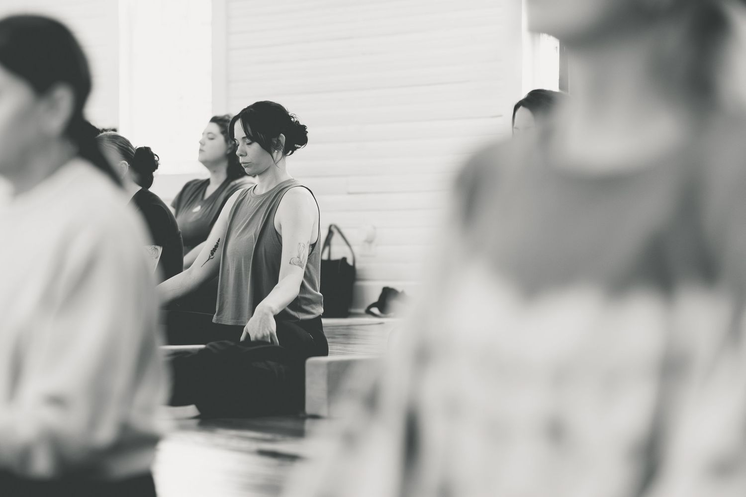 Black and white photo of people standing in church pews during a worship service.