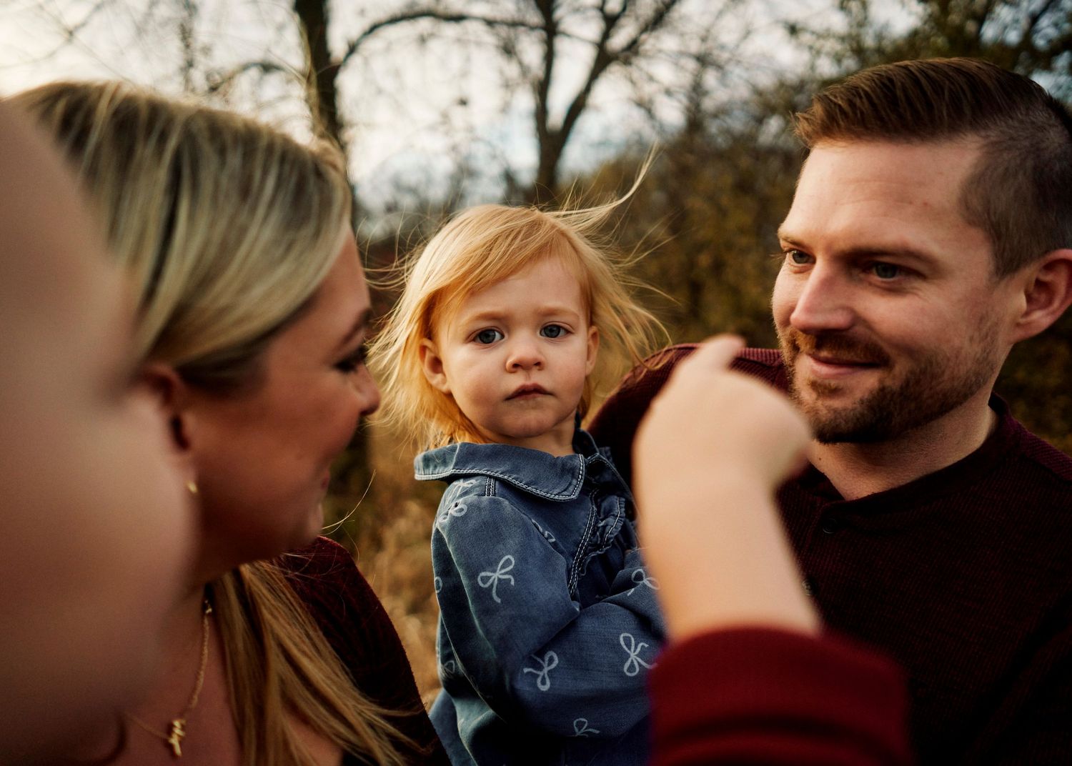 Casual outdoor family portrait session with natural expressions and interactions.