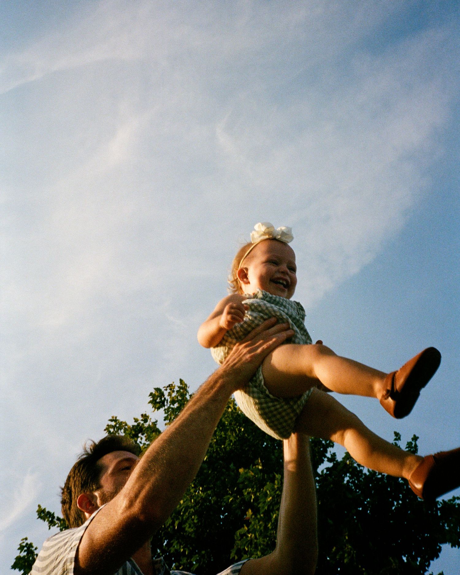 Playful outdoor scene with silhouettes against a bright blue sky.