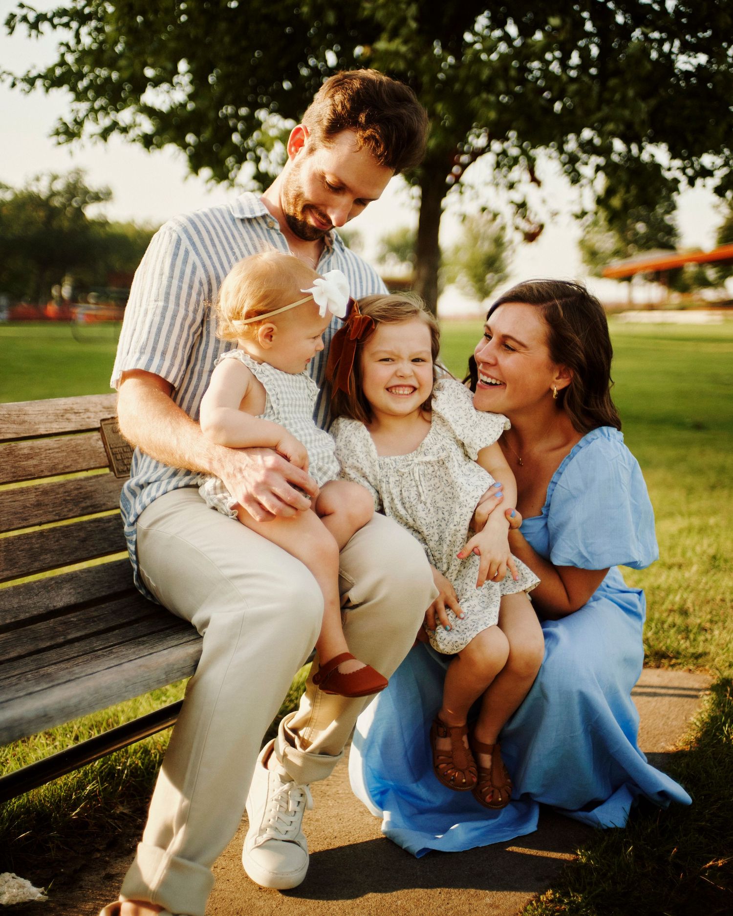 Joyful family moments shared on a wooden park bench at sunset.