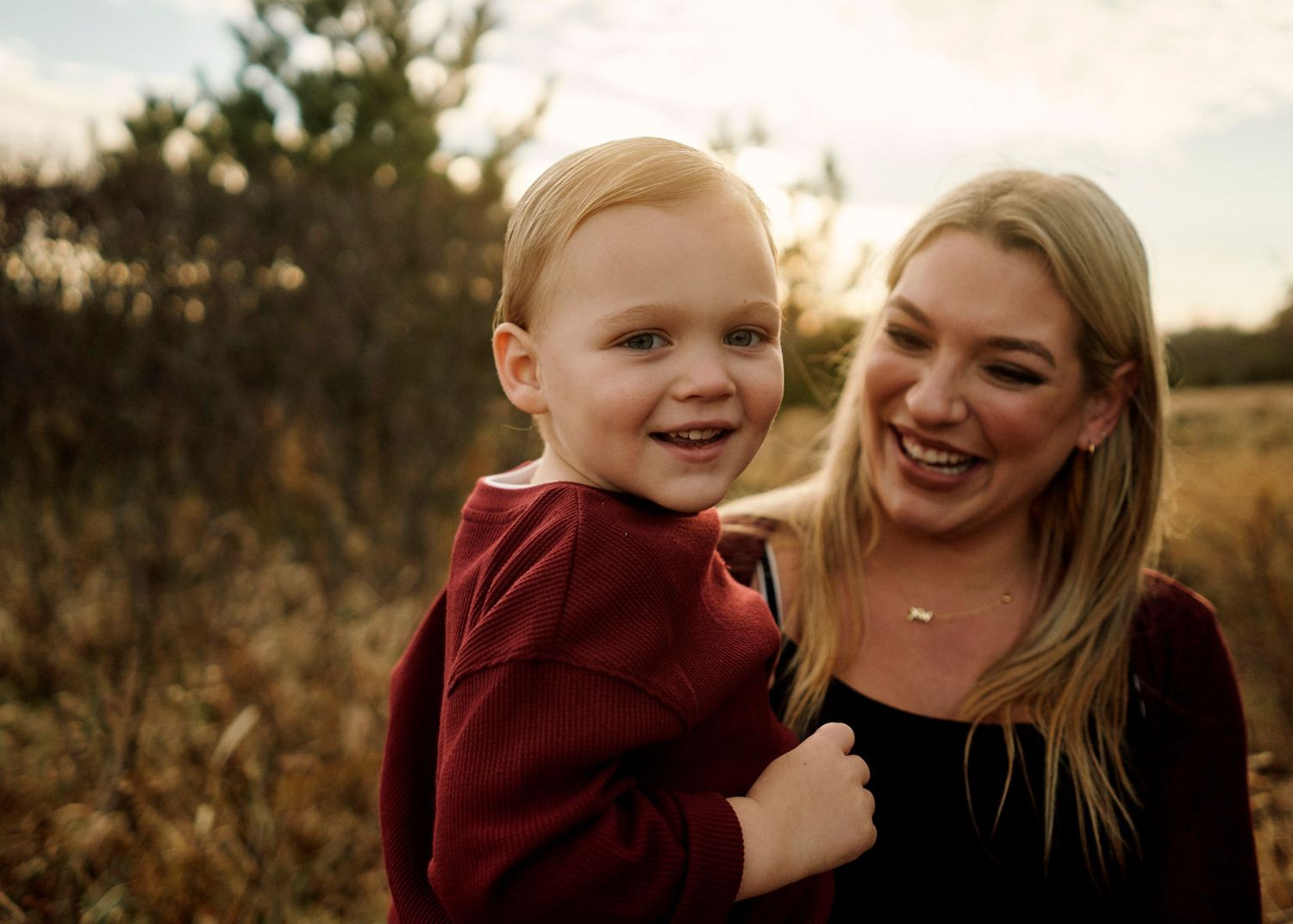 Natural family moments captured with genuine laughter in golden evening light.