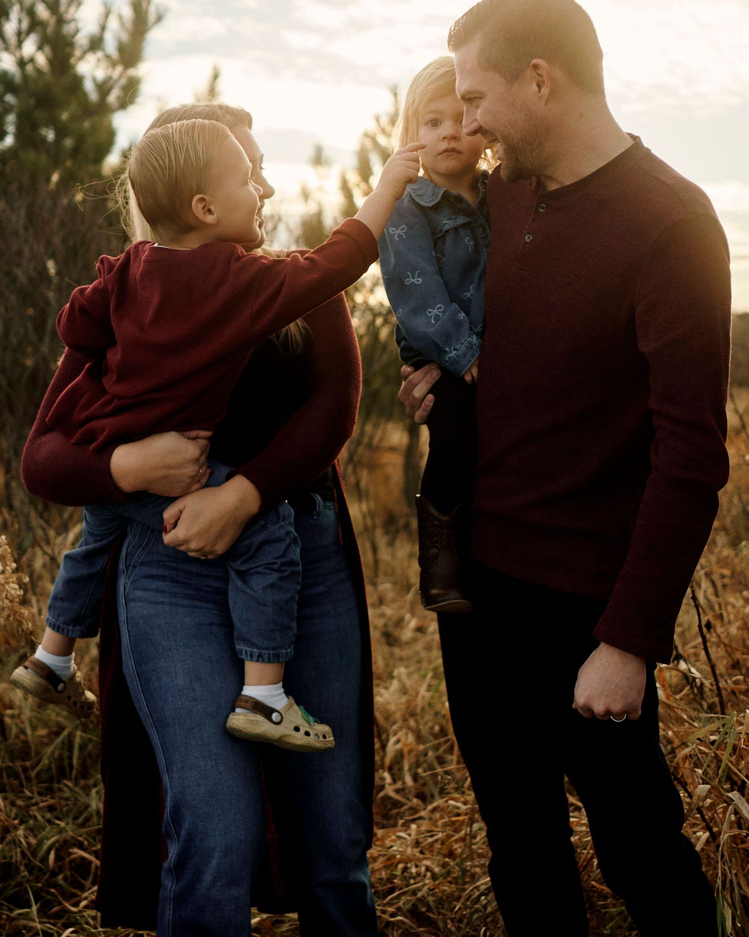 Intimate family moments captured in warm sunlight against natural fall foliage.