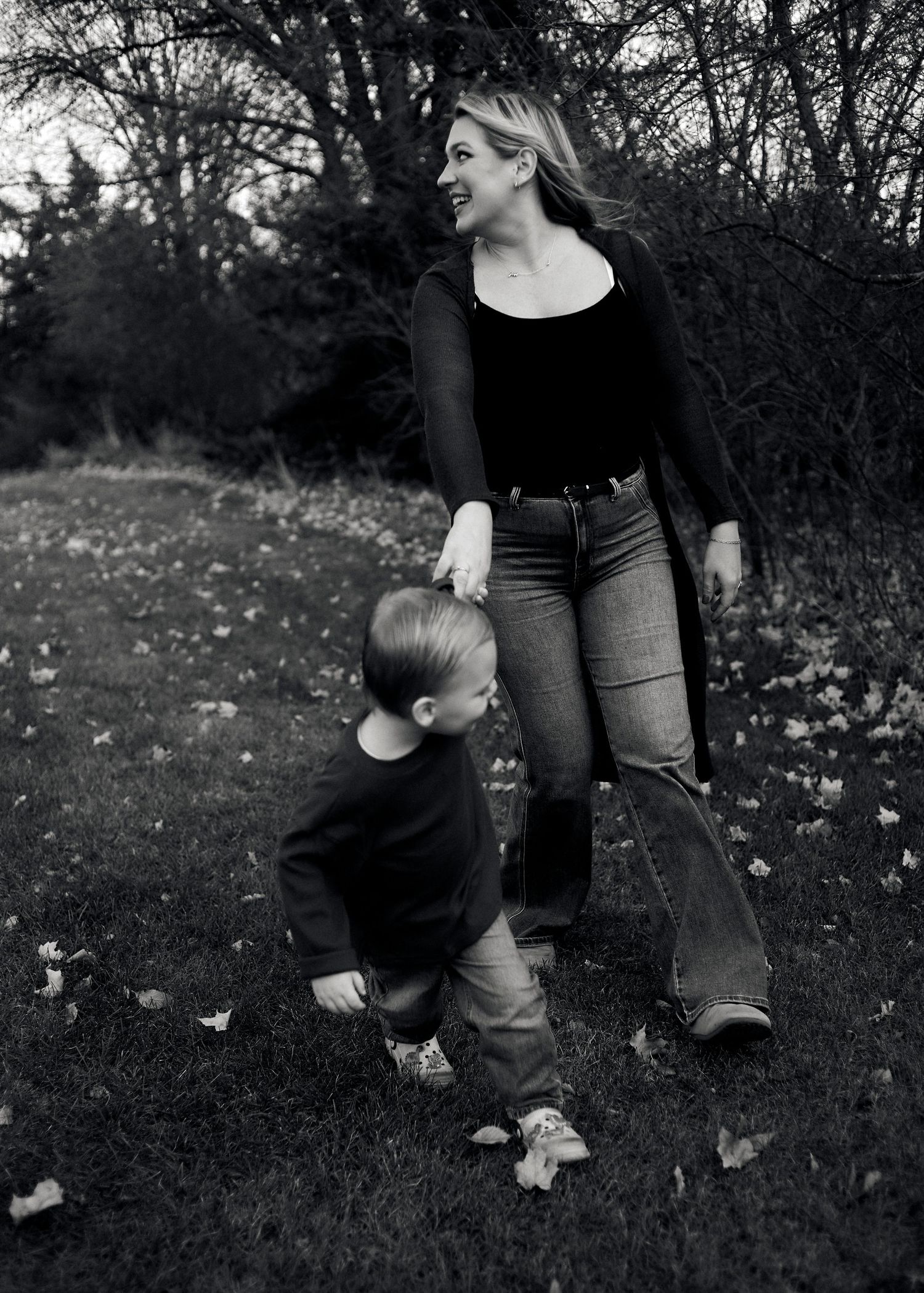 Black and white image showing interaction between two people in a natural setting.