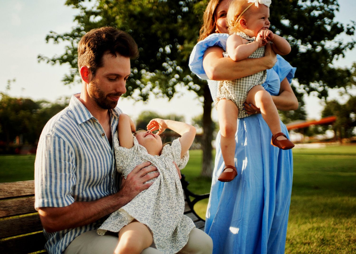 Family sharing tender moments together on a summer evening in the park.