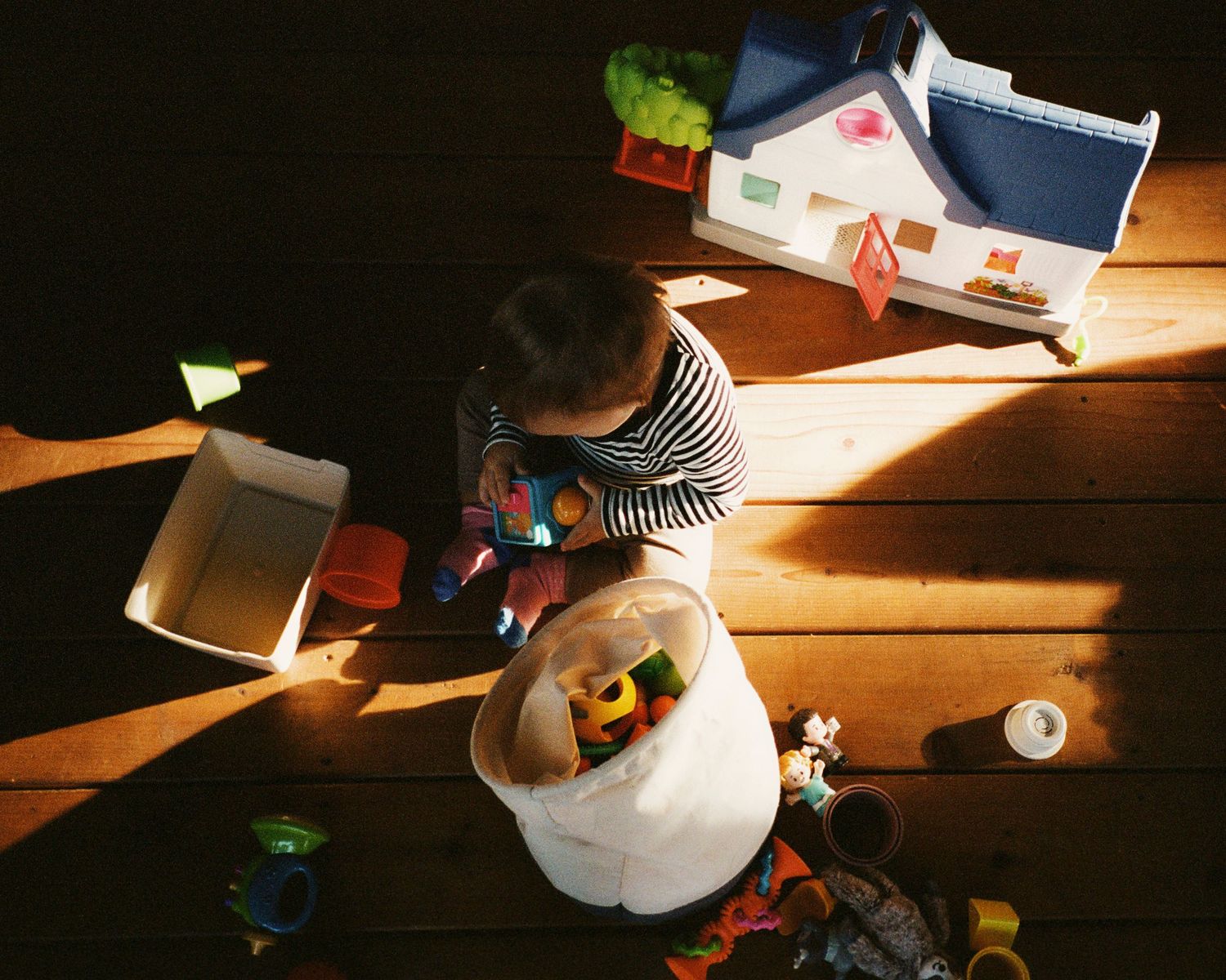A series of eight images showing sunlight casting shadows across a wooden floor with scattered toys and objects.