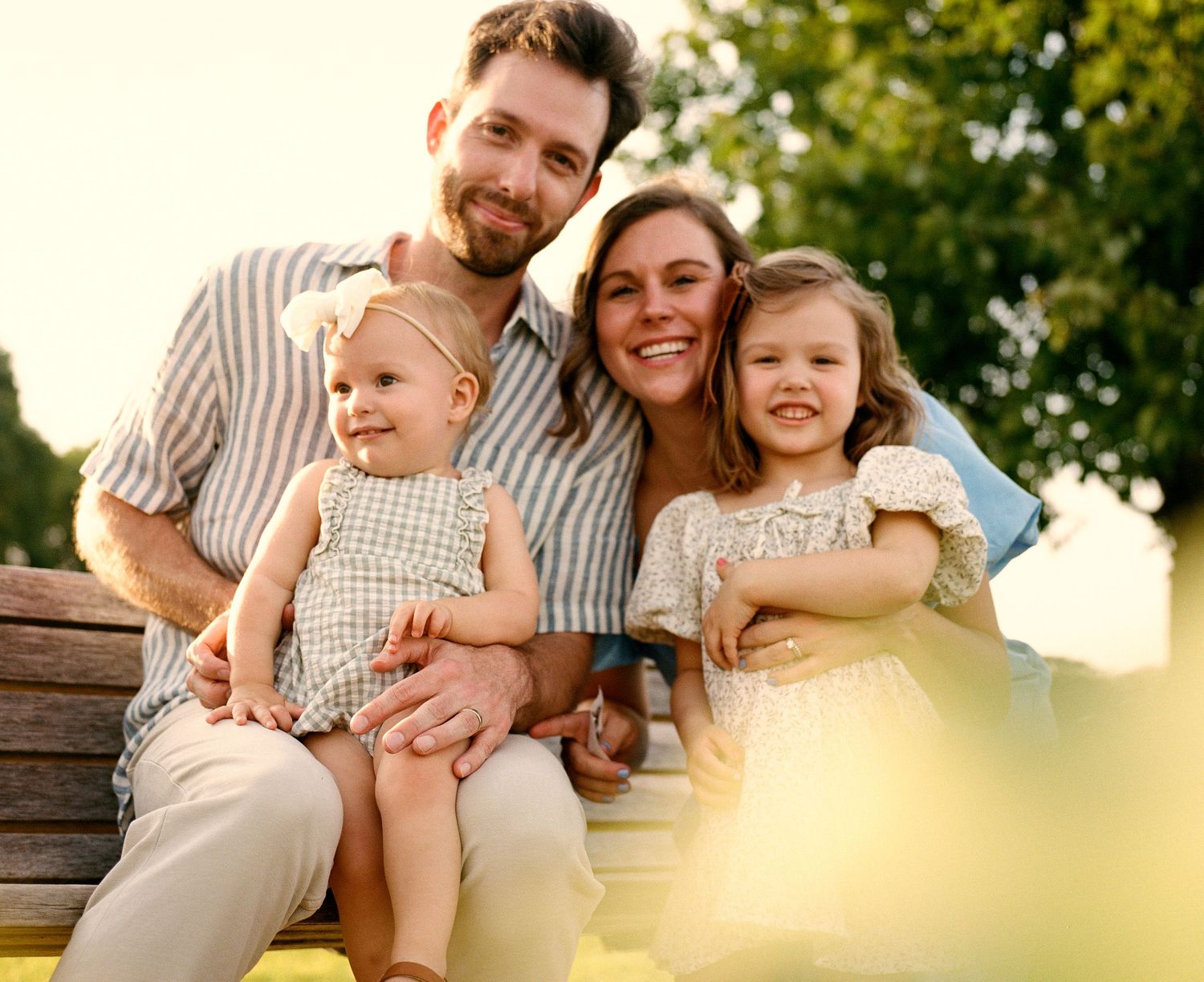 A family shares tender moments together during sunset in a park.