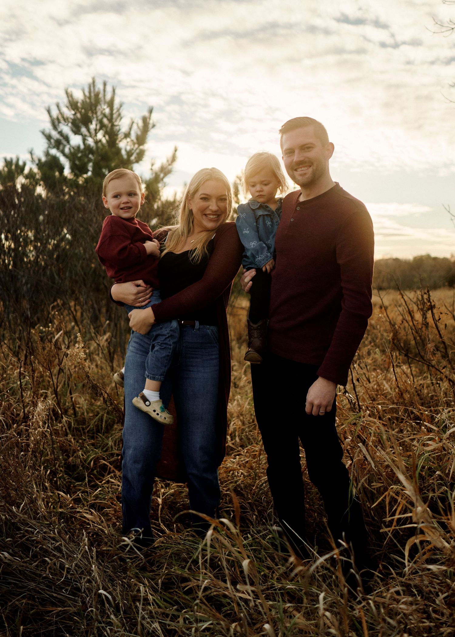 Family enjoying quality time together in a scenic field during sunset.