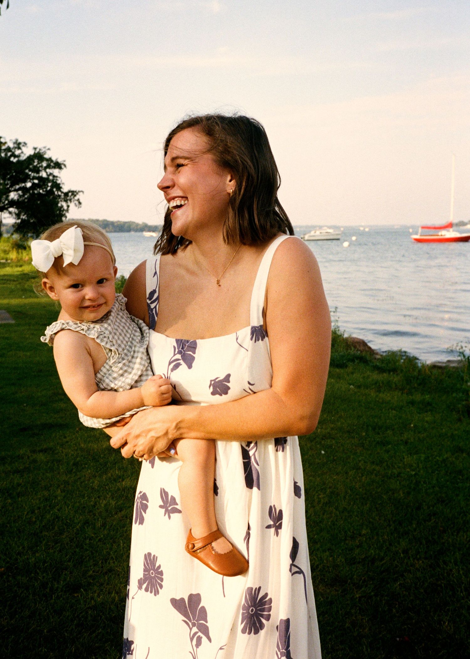 A parent and child share joyful moments together by the water during sunset.