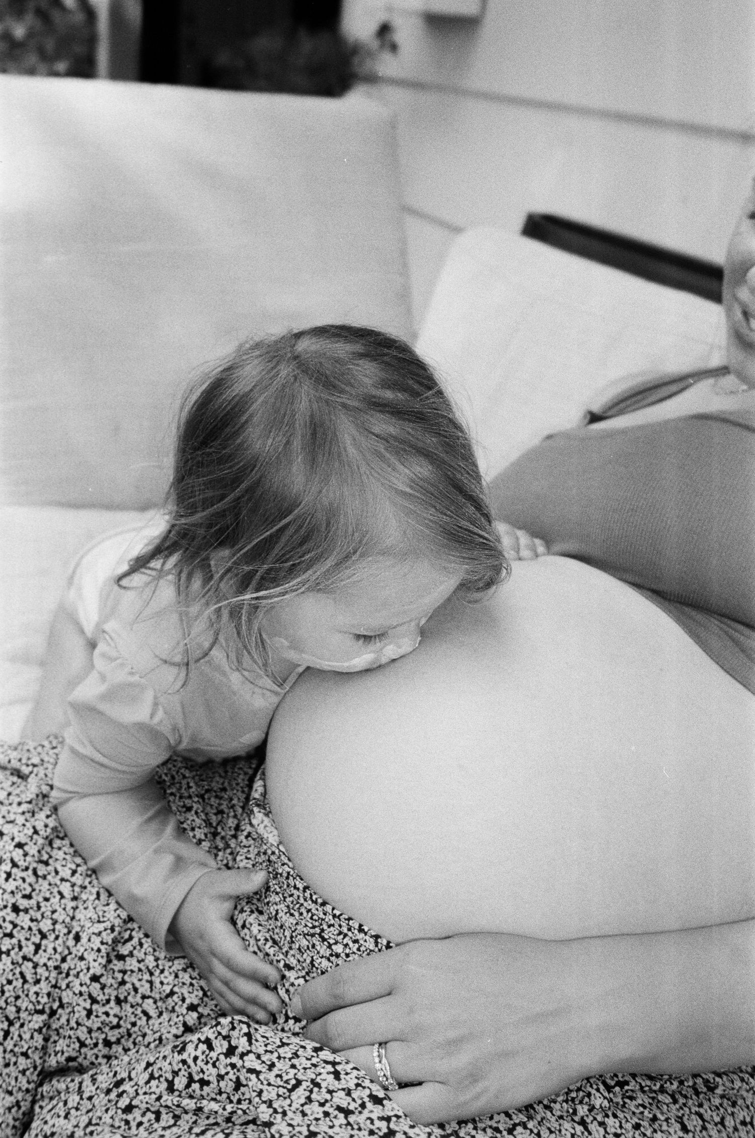 Intimate black and white image showing tender moment between parent and child.