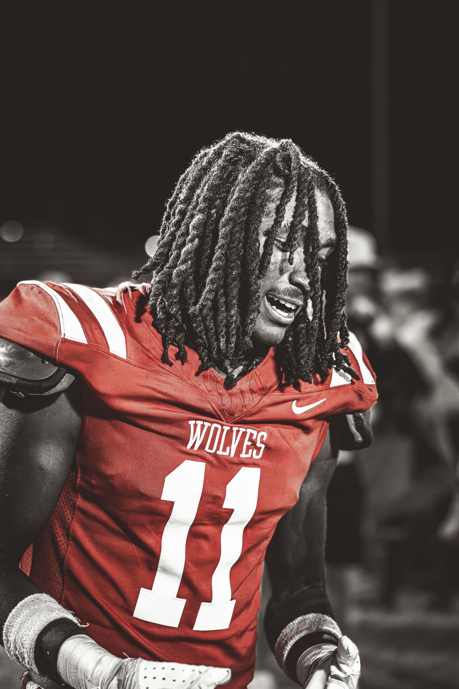 A football player wearing a red jersey with the number 11 on it.